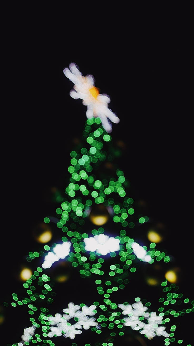Lys op din ferie sæson med smukke julelys hængende fra tagrenderne på et snebelagt hus. Wallpaper