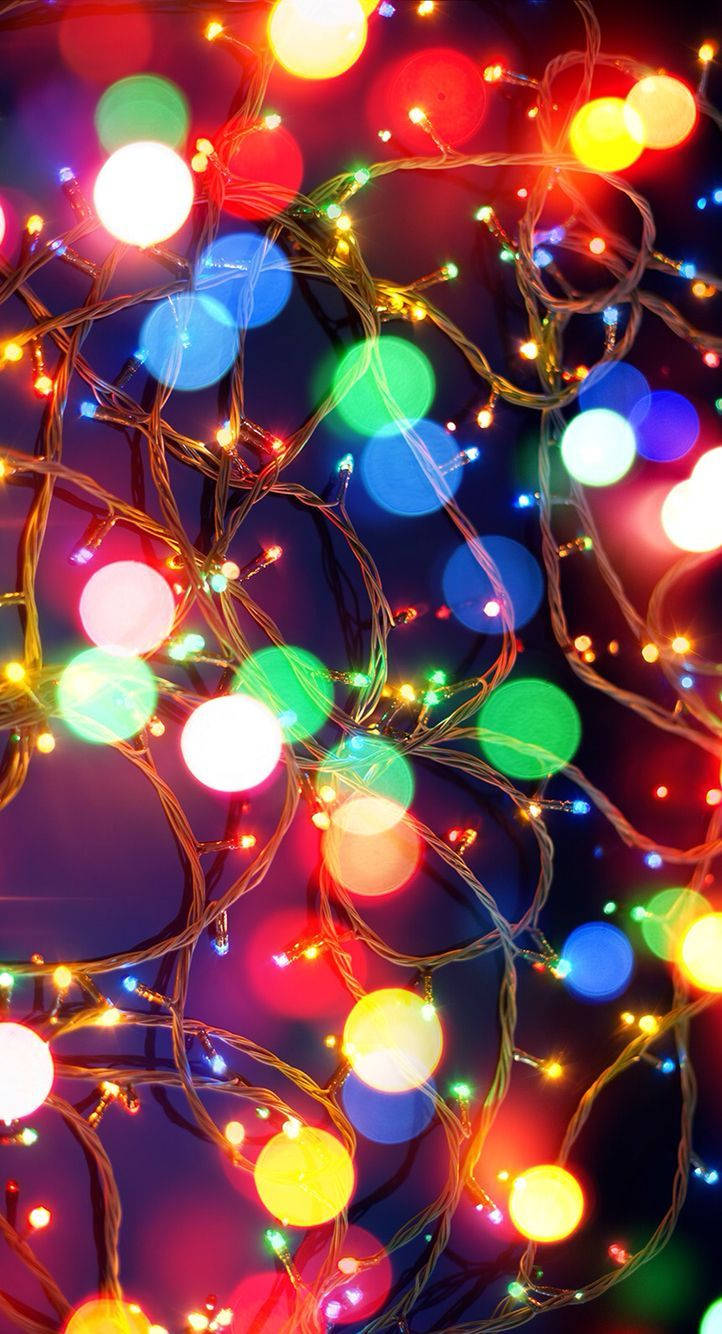 Enjoy a Festive Evening with Christmas Lights on Your Iphone Wallpaper