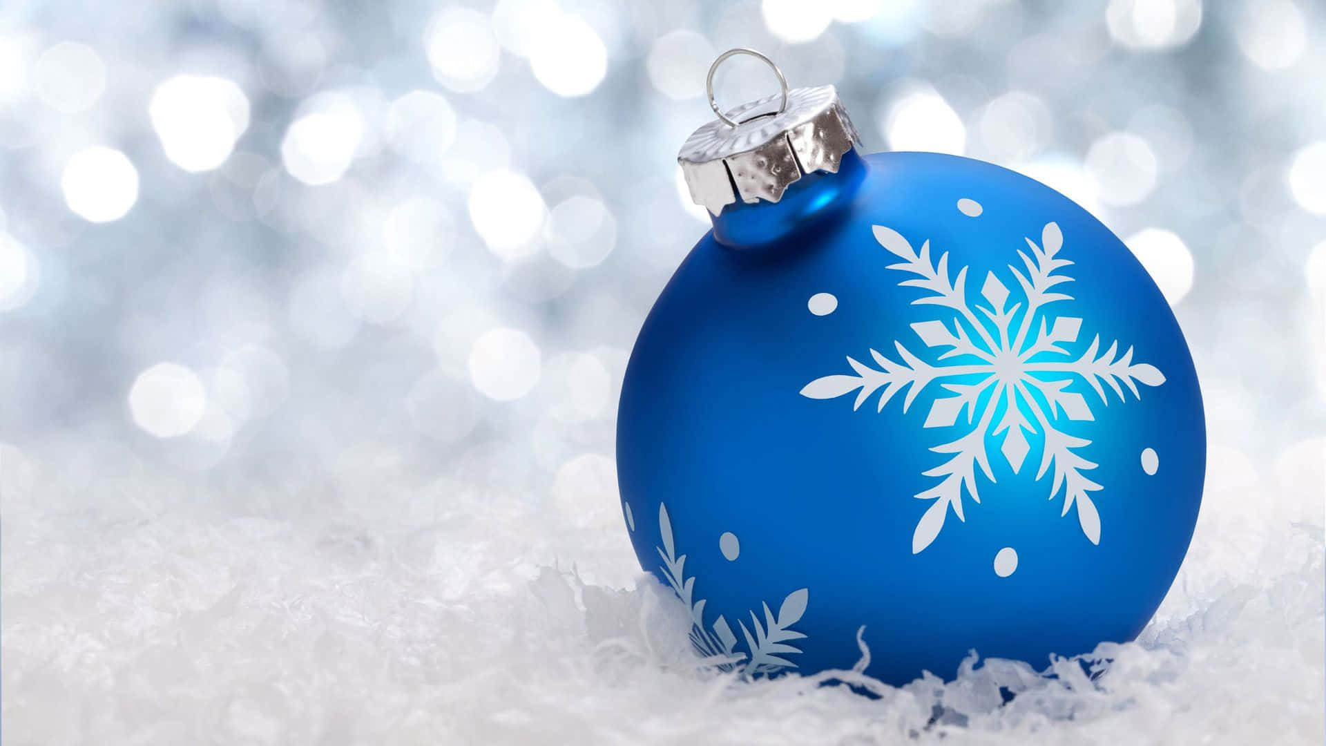En blå julekugle med snefnug på den Wallpaper