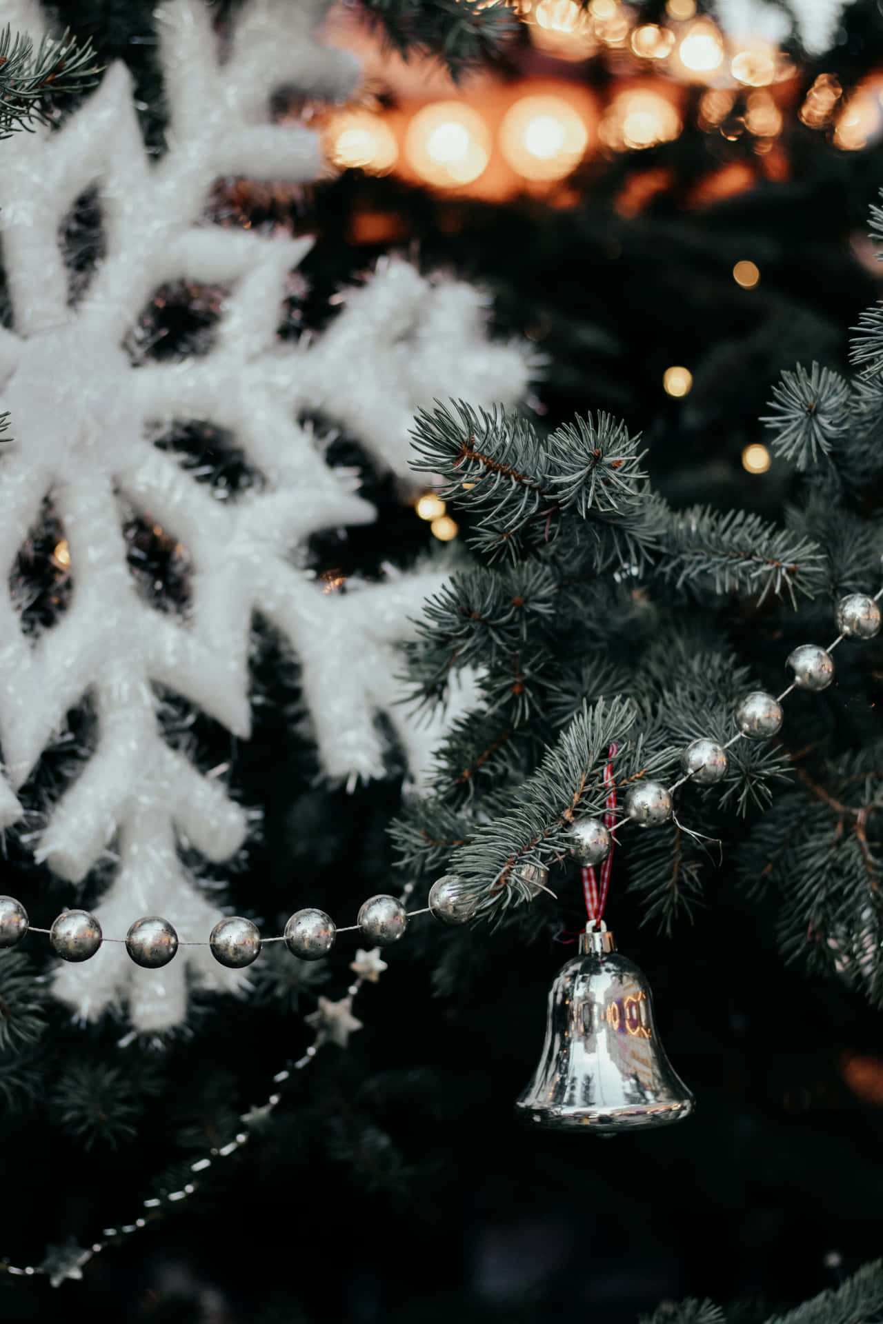 A Christmas Tree With A Bell And Snowflakes
