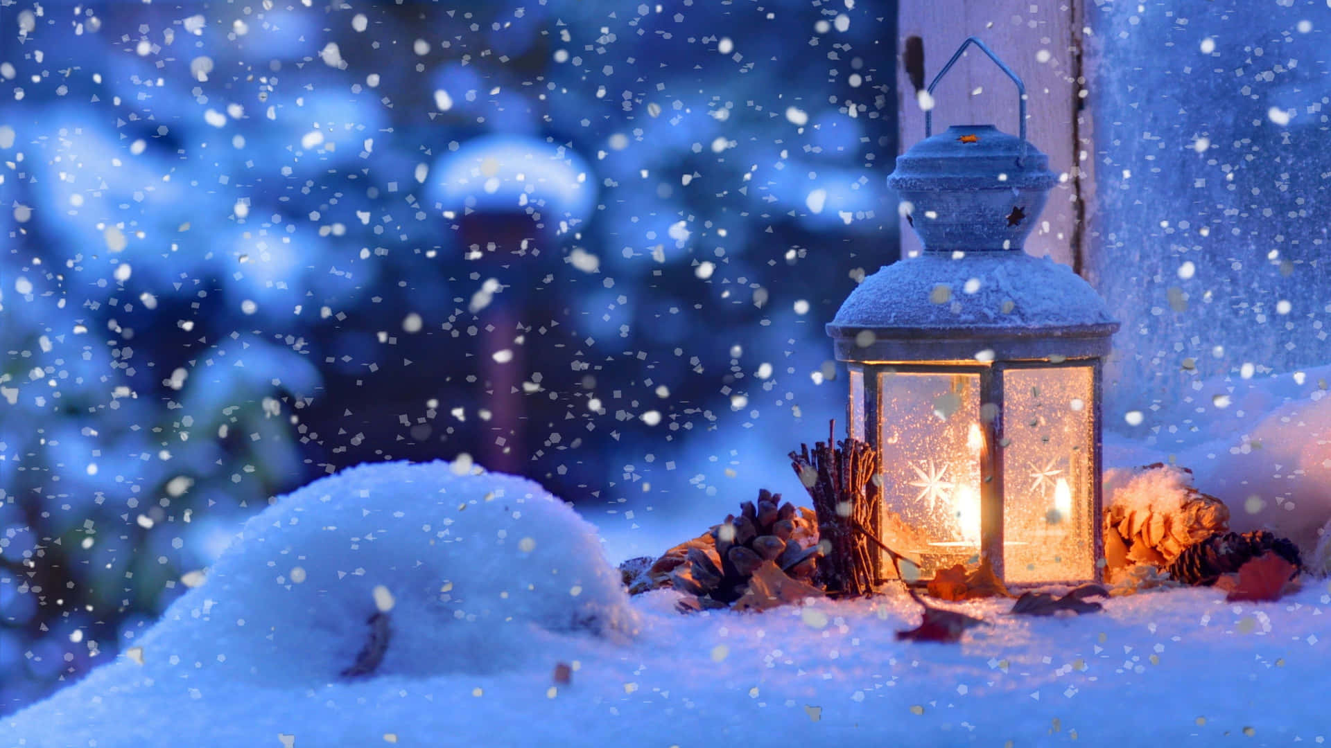 En lanterne sidder på en sne-dækket vindueskarme. Wallpaper