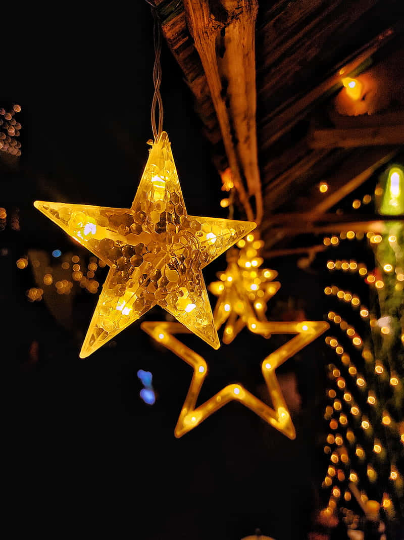 Two Star Lights Hanging From A Tree Wallpaper