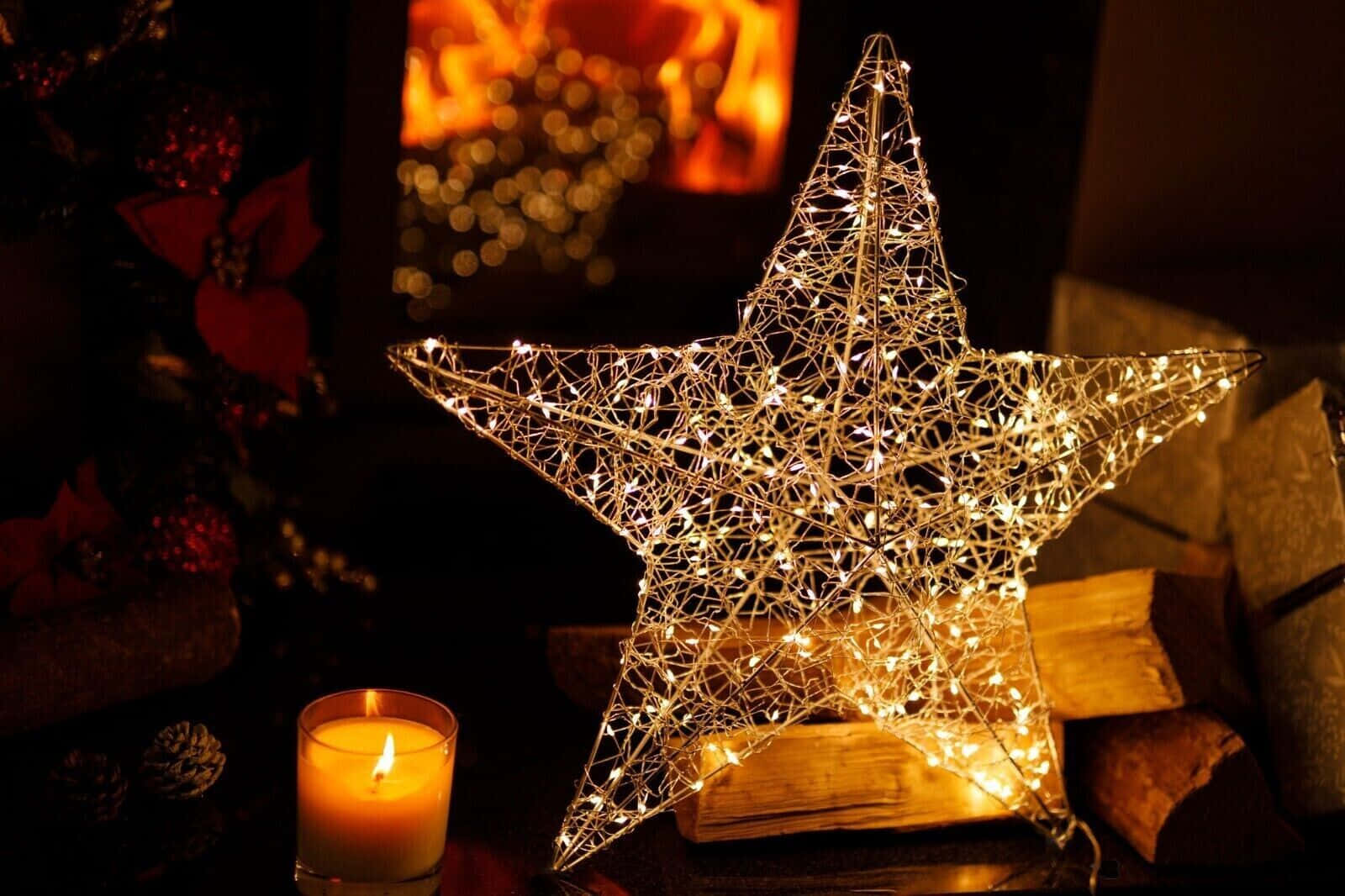 A twinkling silver Christmas star lights up the night sky. Wallpaper
