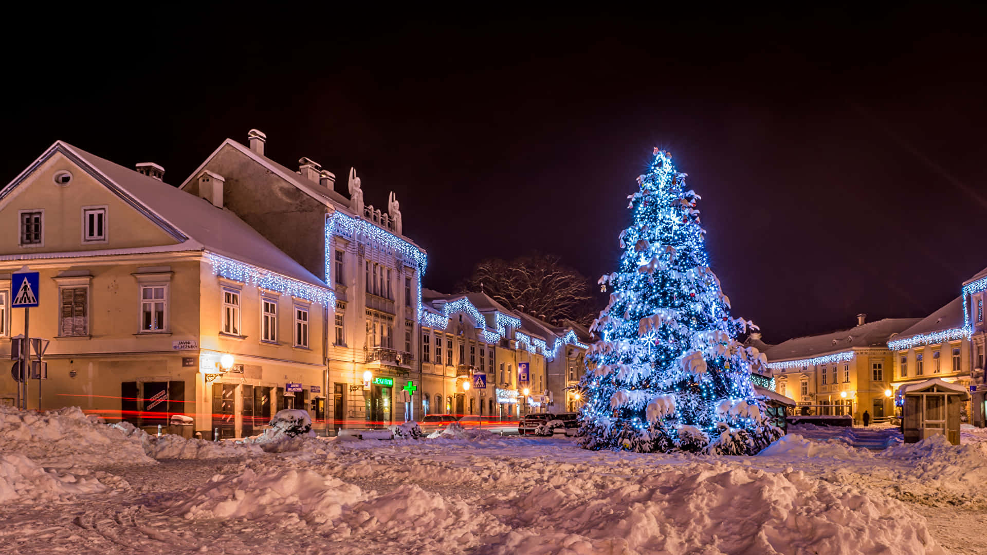 A Christmas Tree In A Snowy Town Wallpaper