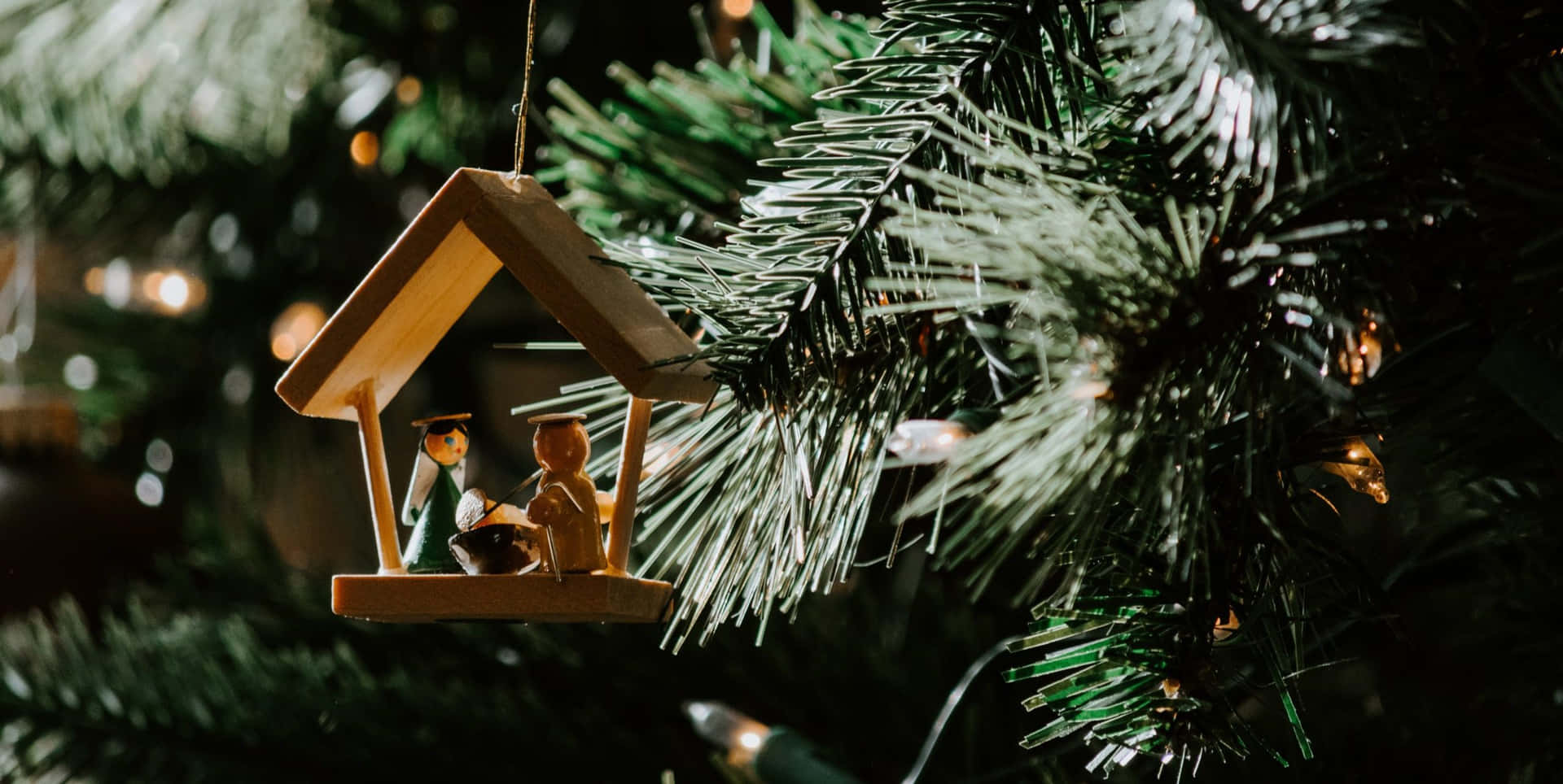 A Wooden House Hanging On A Christmas Tree