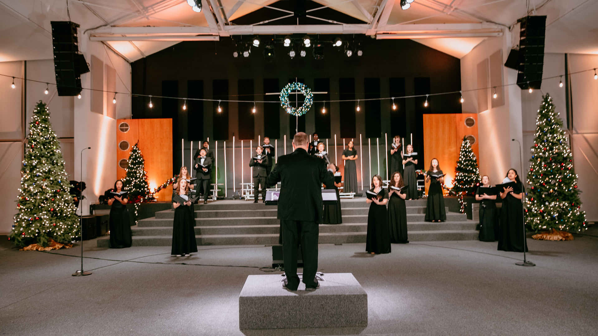 A Choir Performs In A Church With Christmas Trees