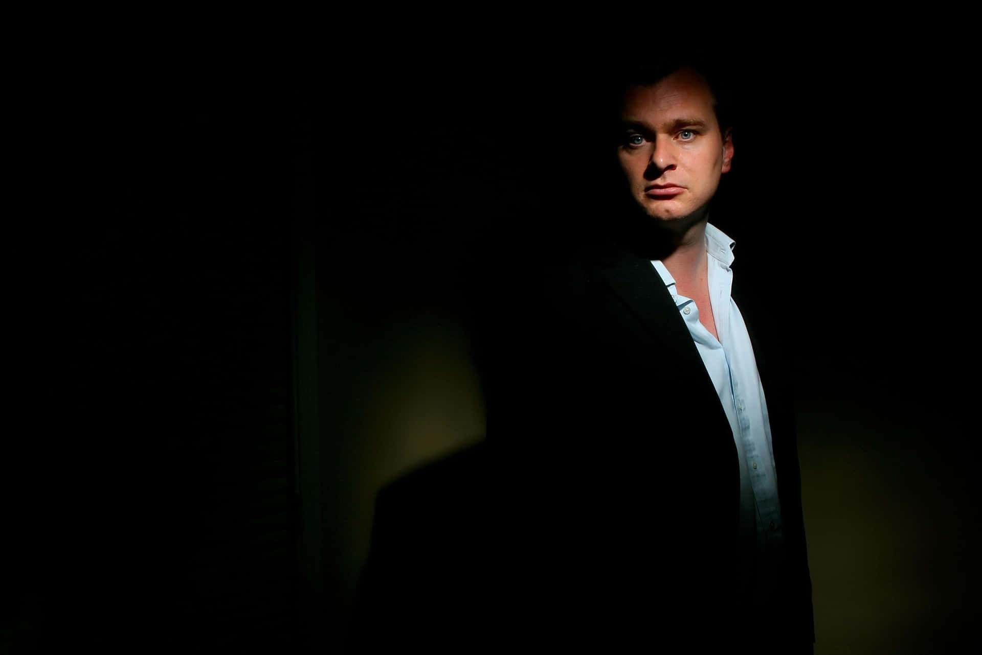 A creative portrait of genius filmmaker Christopher Nolan against a stunning backdrop Wallpaper