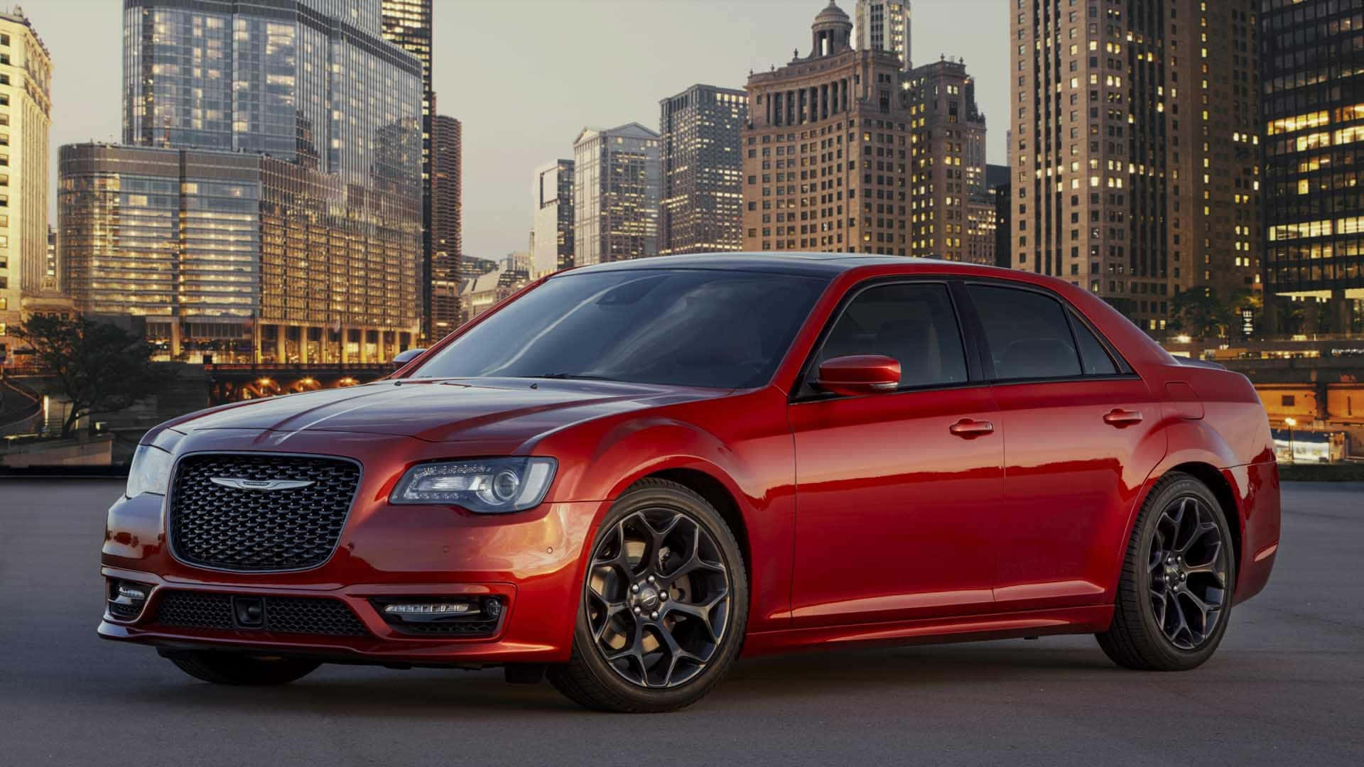 The Red Chrysler 300 Is Parked In Front Of A City