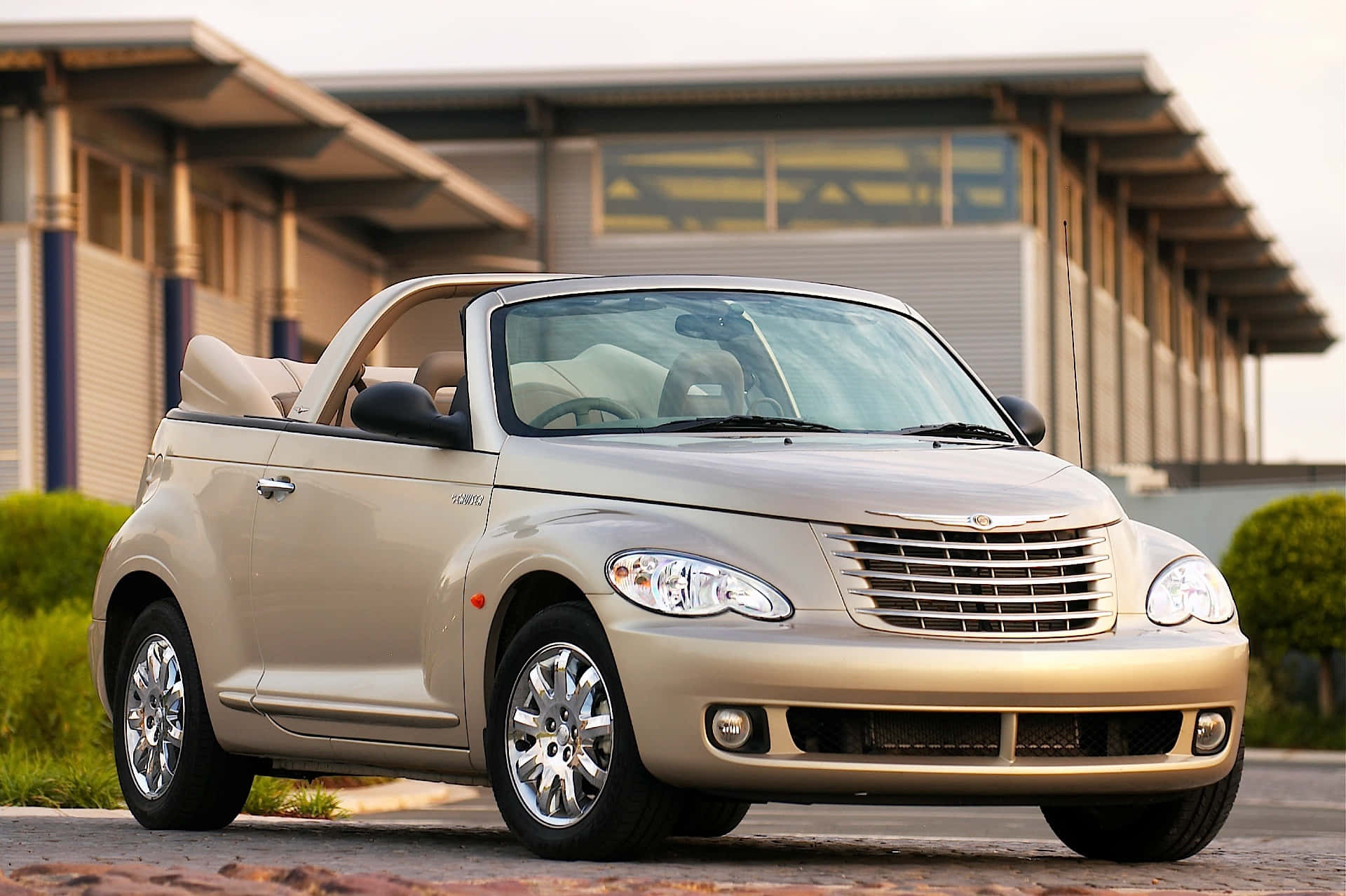 Caption: Sleek Red Chrysler PT Cruiser on a City Street Wallpaper