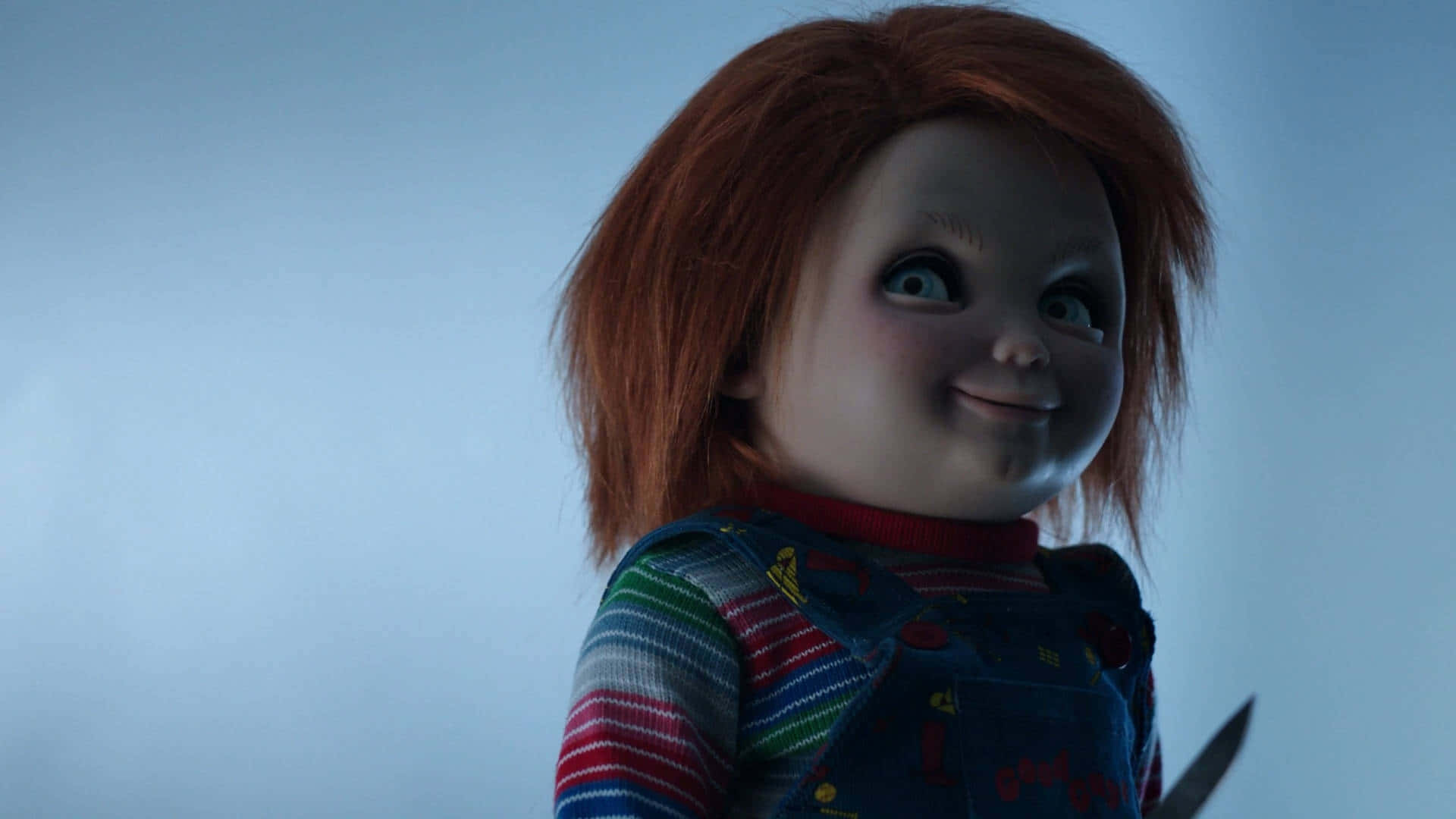 En dukke med rødt hår holder et kniv Wallpaper