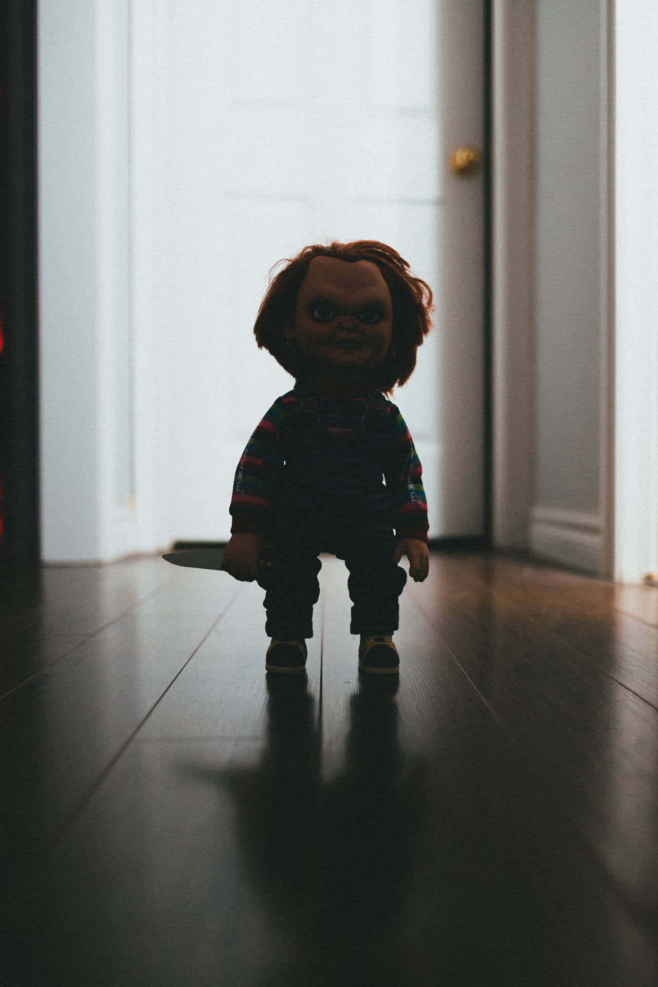 Chucky Doll Standing In The Hallway Wallpaper