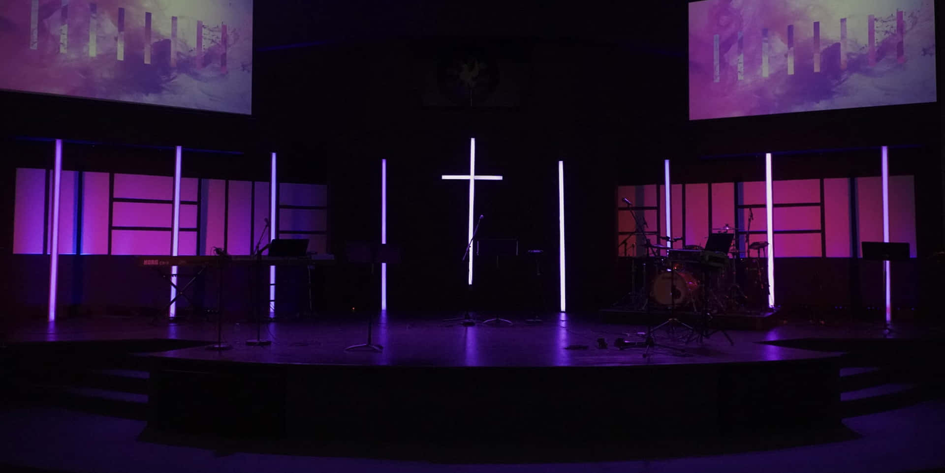 A vibrant lights and drawings on the stage of a church bring more life and beauty to the message being delivered.