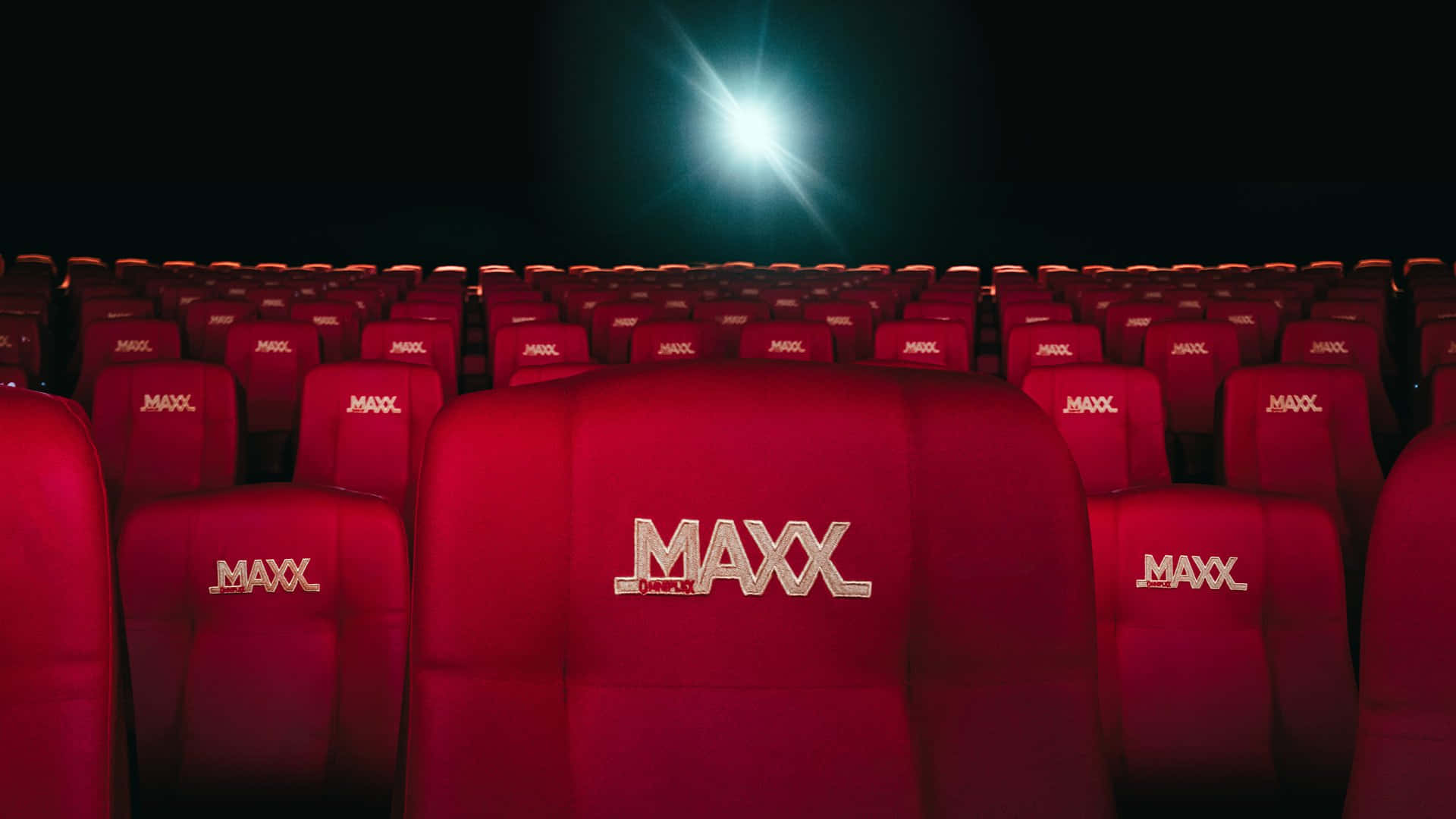 A Row Of Red Seats In A Movie Theater Wallpaper