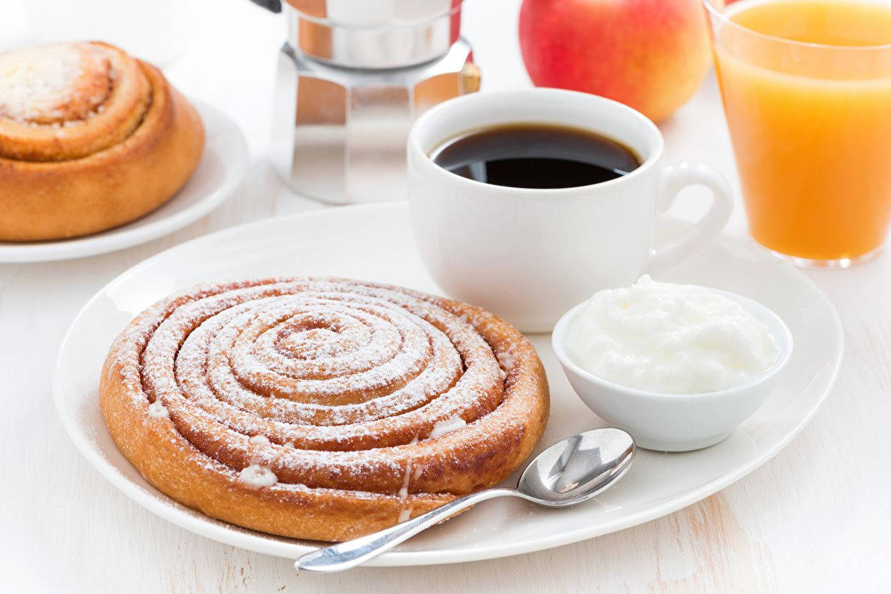 Cinnamon Roll With Confectioner Sugar And Coffee Wallpaper
