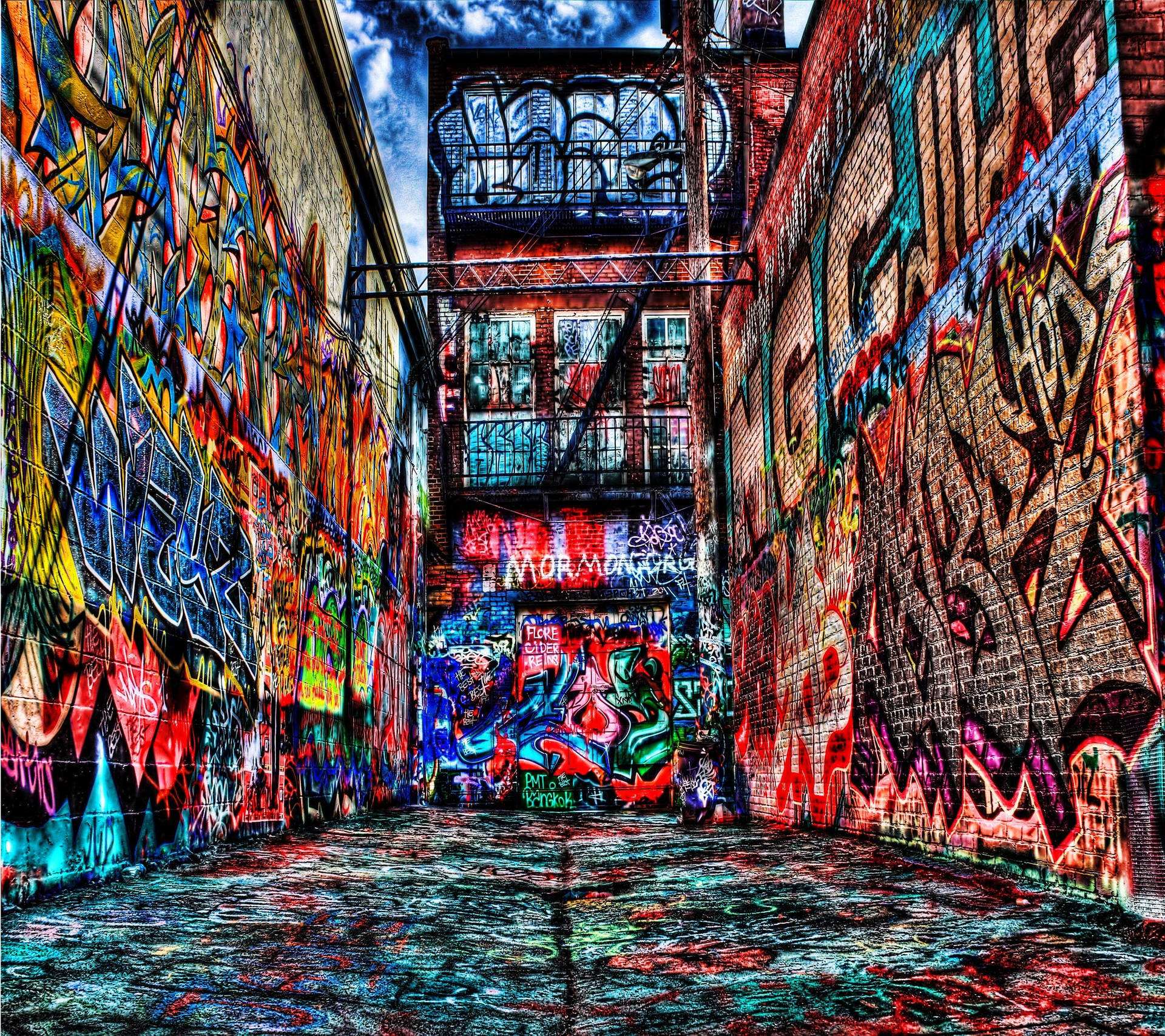 Wallpaper of large city buildings completely filled with graffiti.
