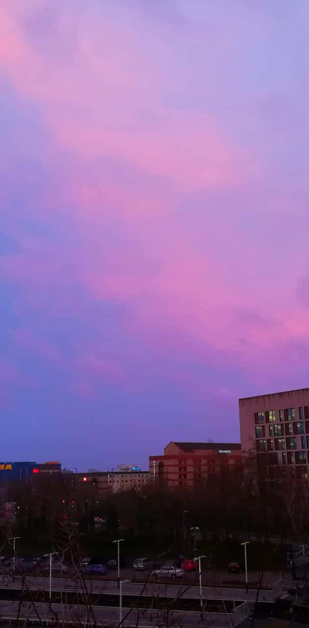 Disfrutade La Ciudad Iluminada Con Colores Durante El Atardecer. Fondo de pantalla