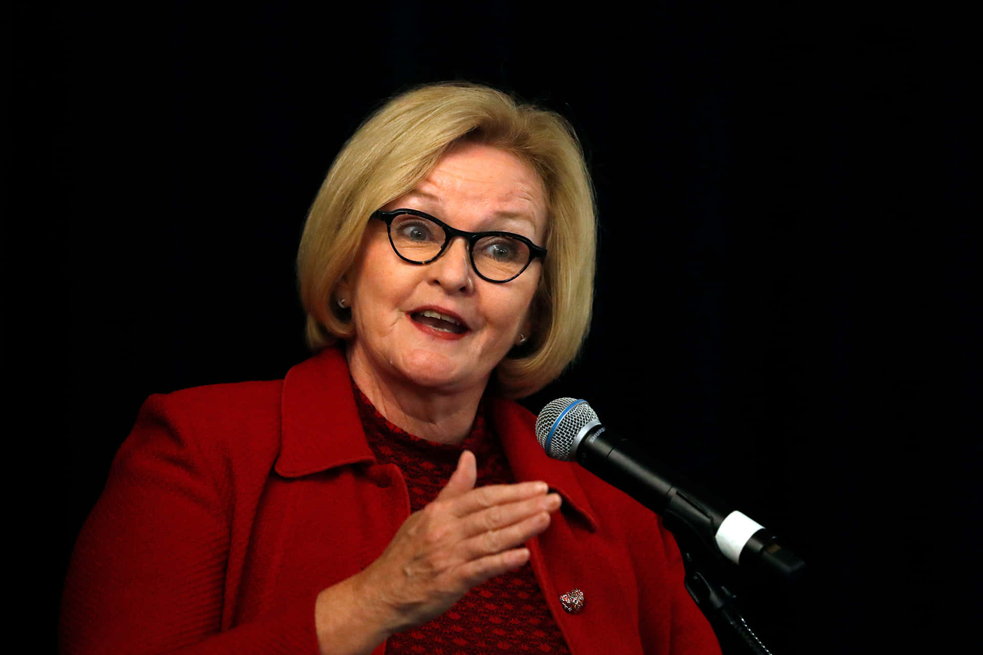 Claire Mccaskill Gesturing With Microphone Background