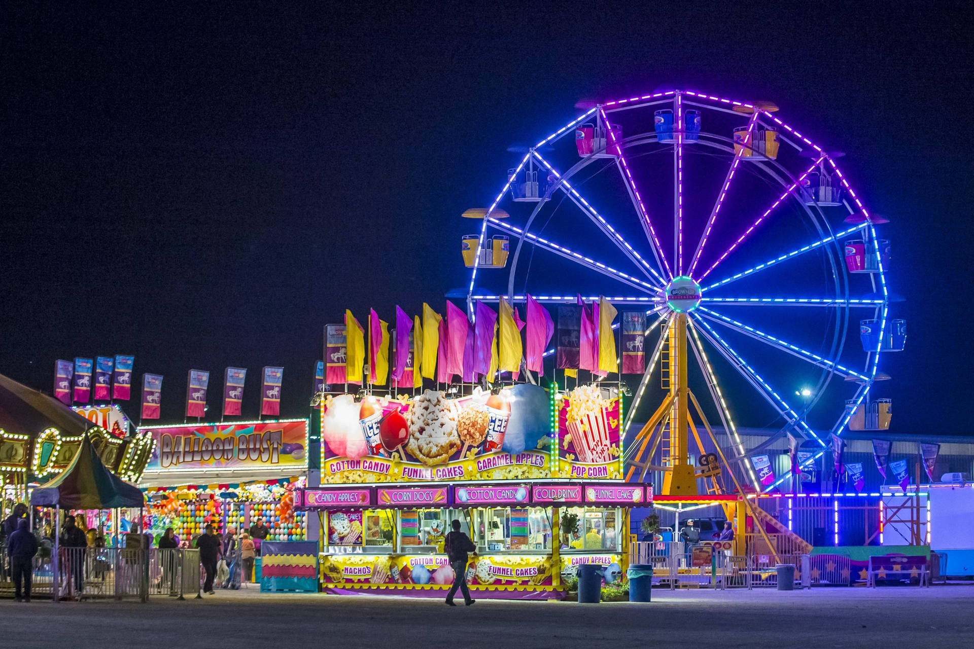 Caption: "Thrilling rides and vibrant lights at the Clark County Fair and Rodeo" Wallpaper
