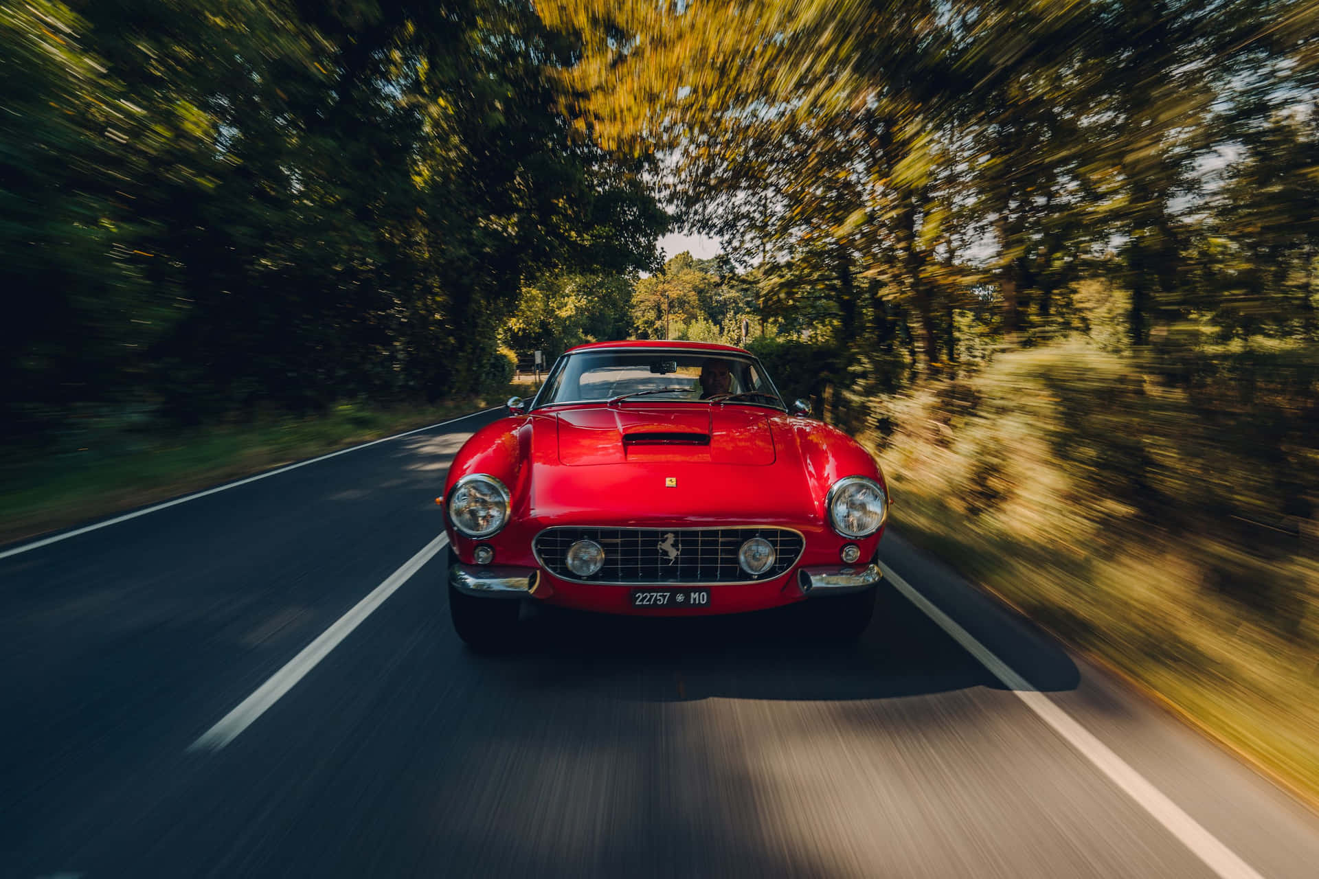 Driving in Style - A classic Ferrari on the open road Wallpaper