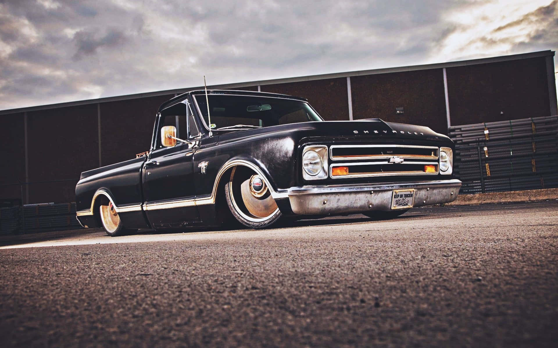 Classic Lowered Truck Against Cloudy Sky Wallpaper