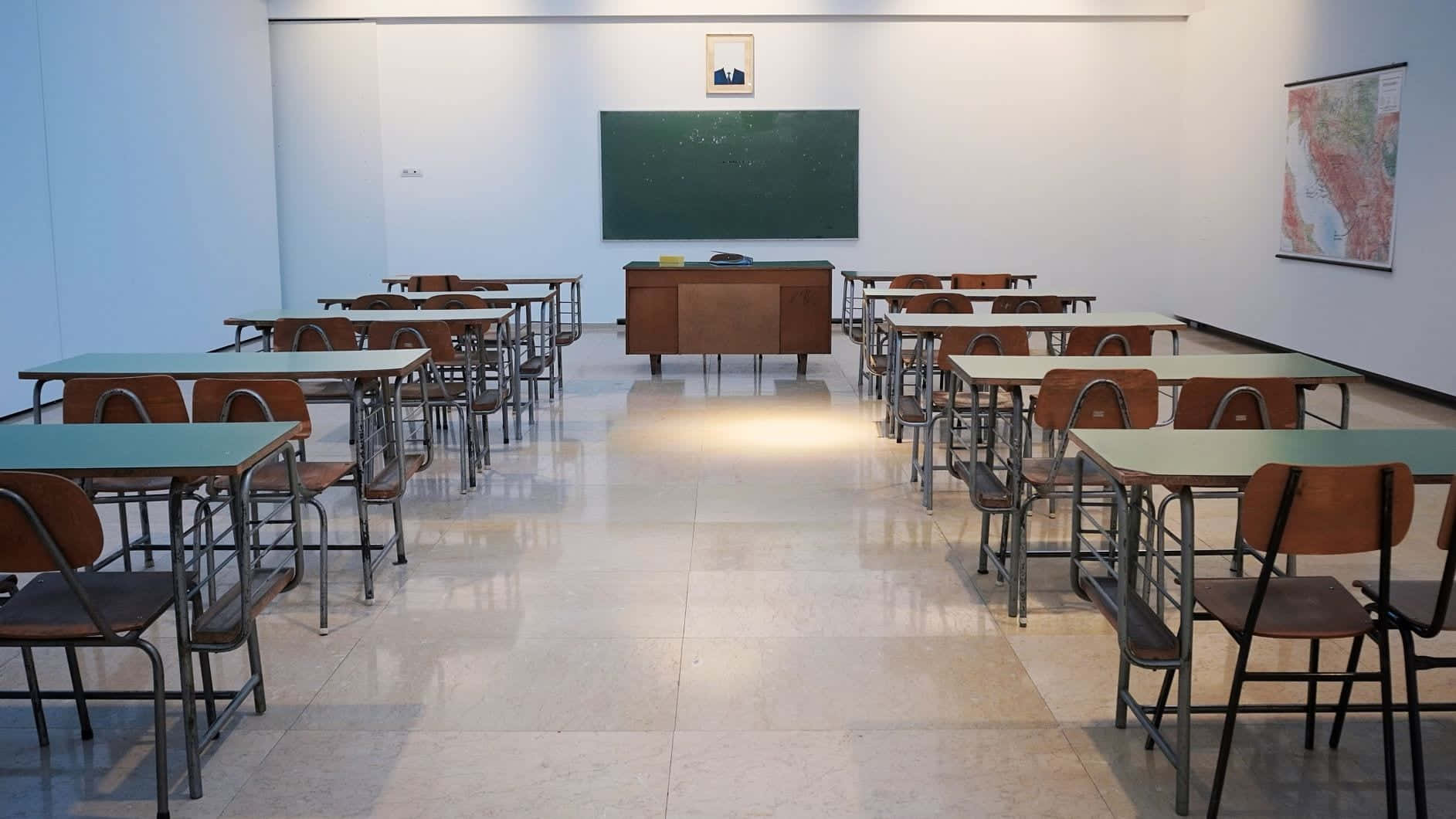 A Classroom With Desks And A Chalkboard