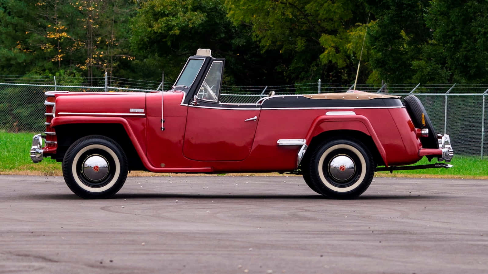 Classy And Rugged Jeepster Prowling Through The Wilderness Wallpaper