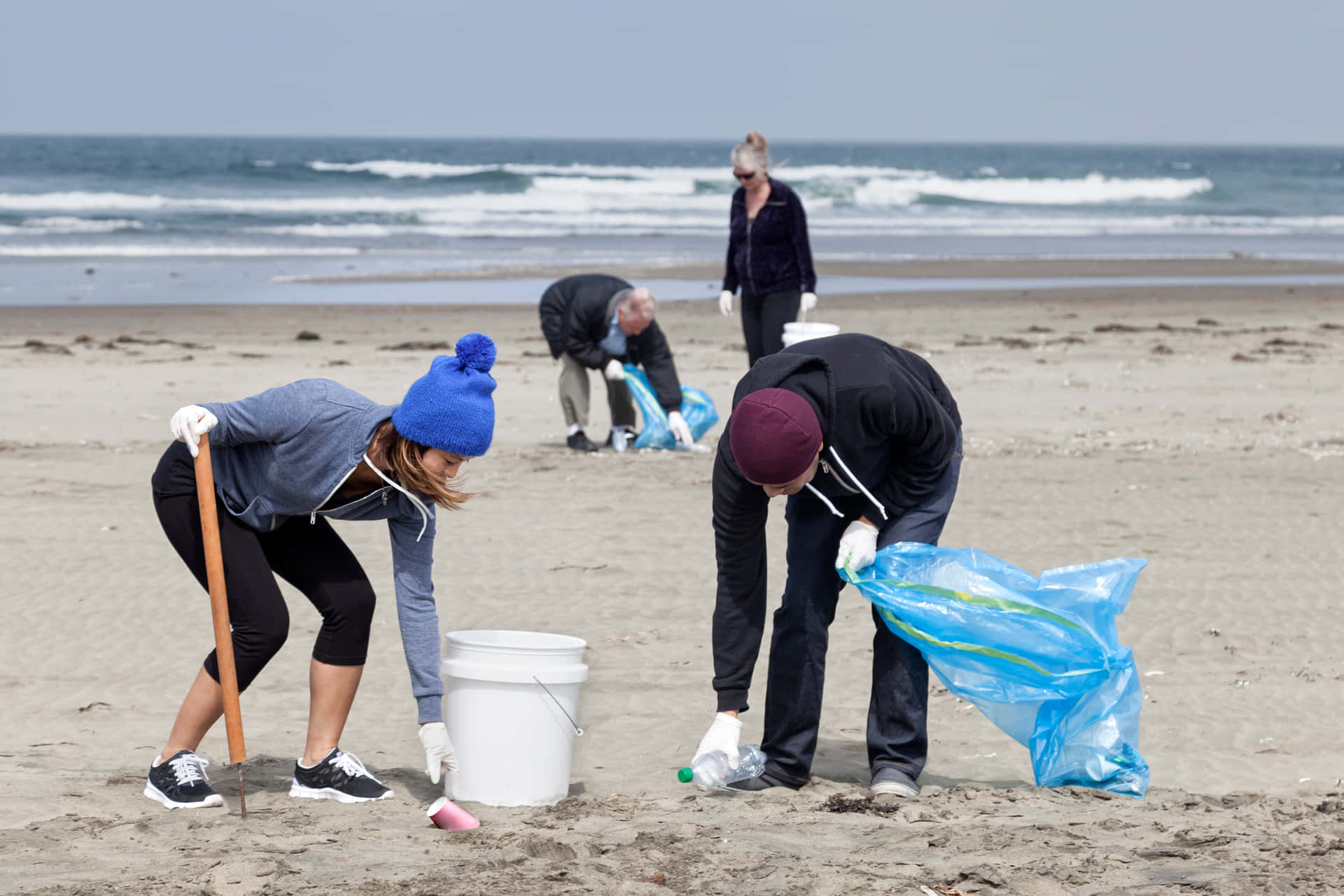 A Group Of People Cleaning Up The Beach
