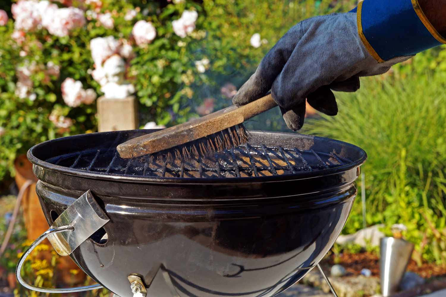 A Person Is Cleaning A Bbq Grill