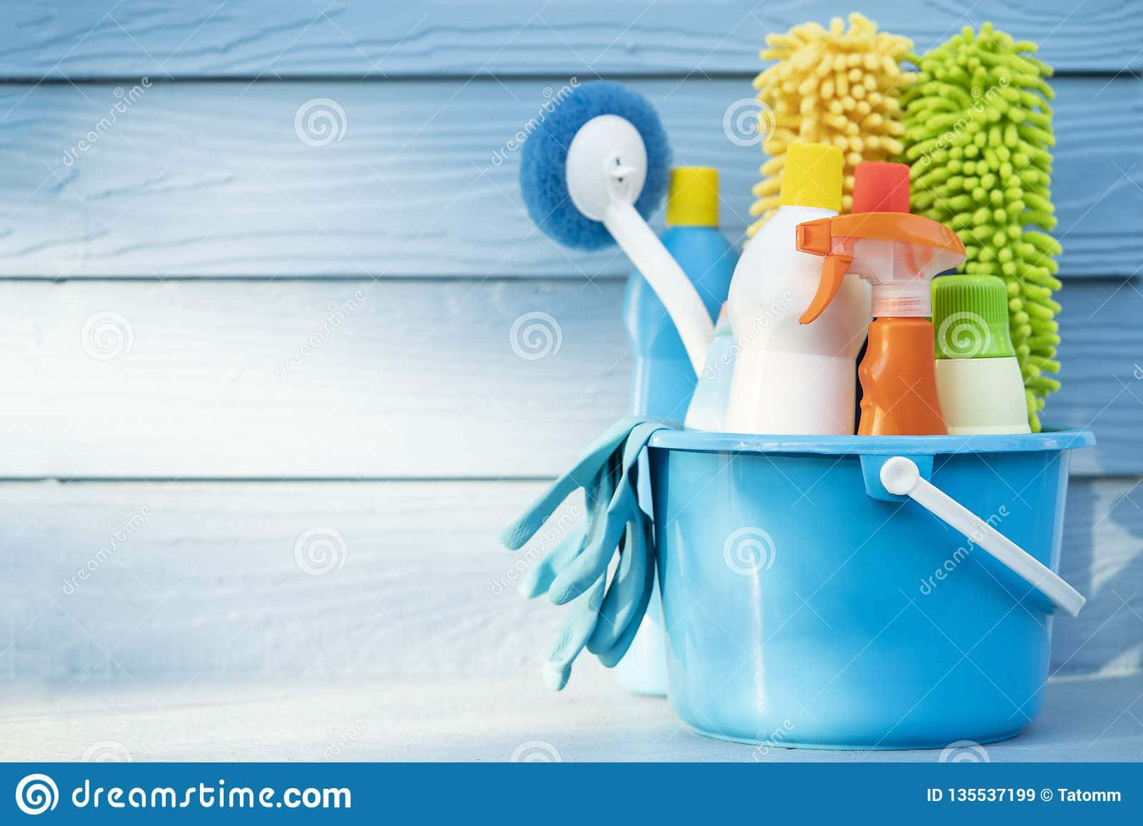 Cleaning Supplies In A Bucket On A Wooden Background