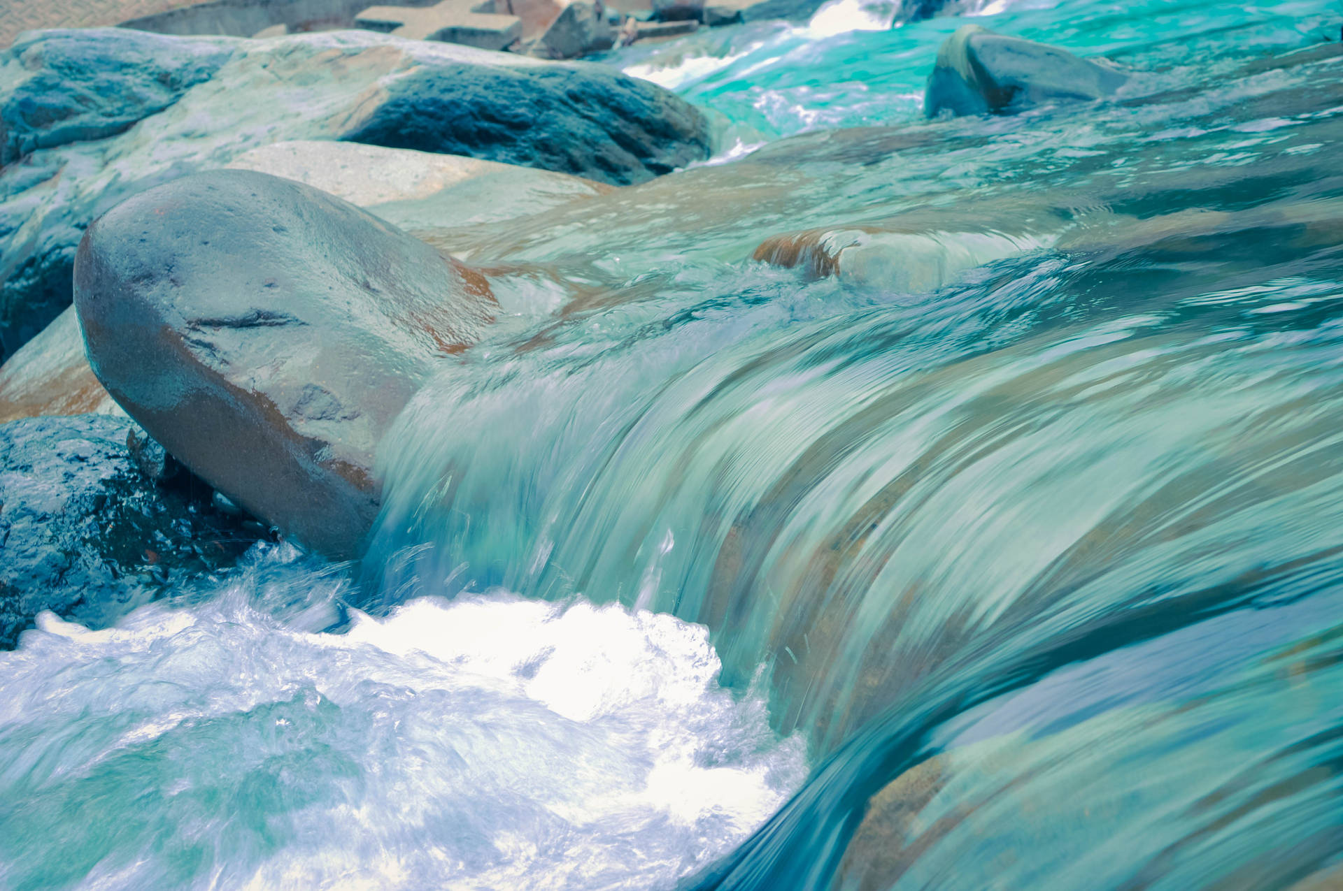 A clean blue river cascading through the landscape Wallpaper