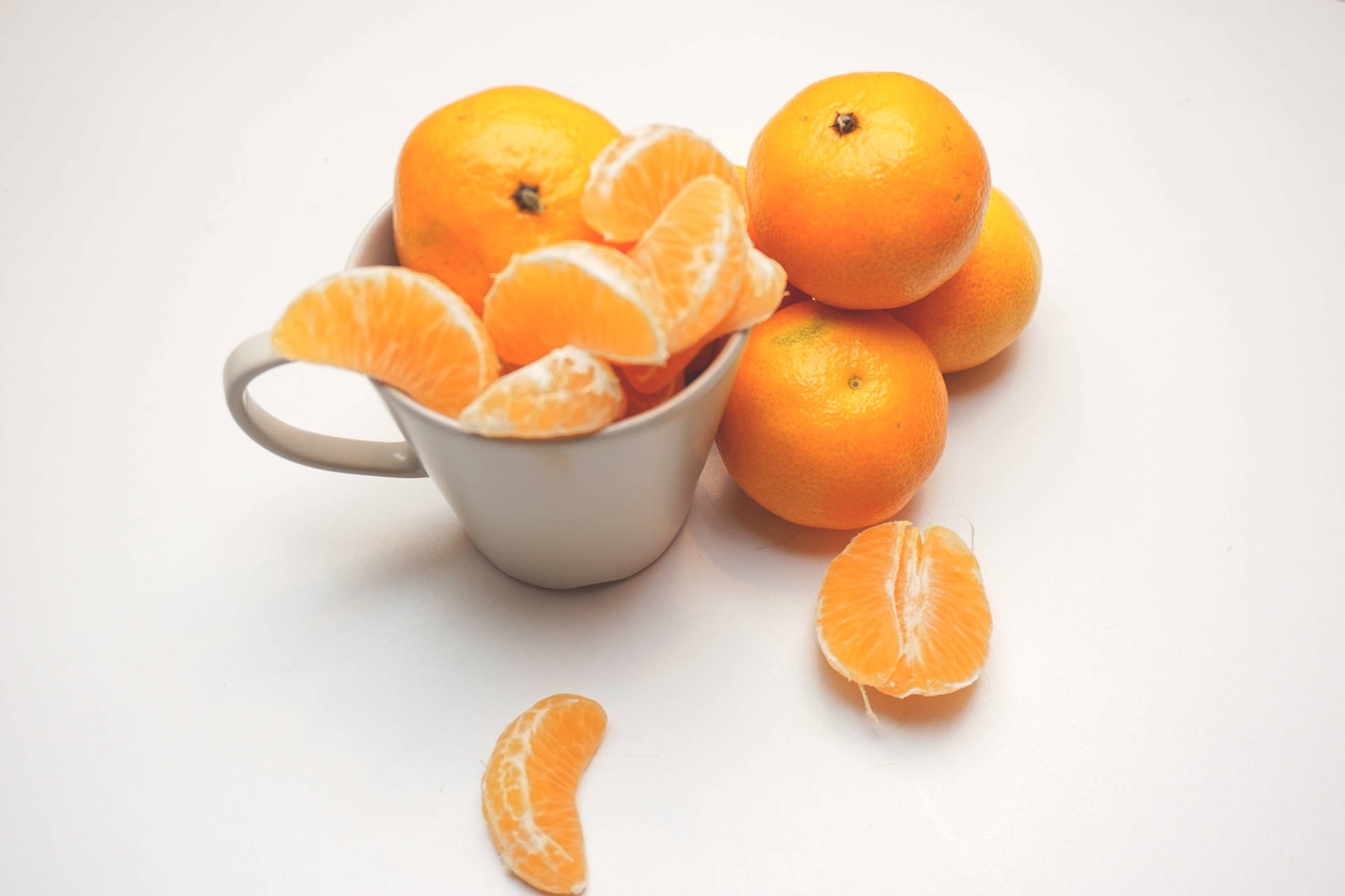 Clementine Citrus Fruits Overloading On Cup Wallpaper