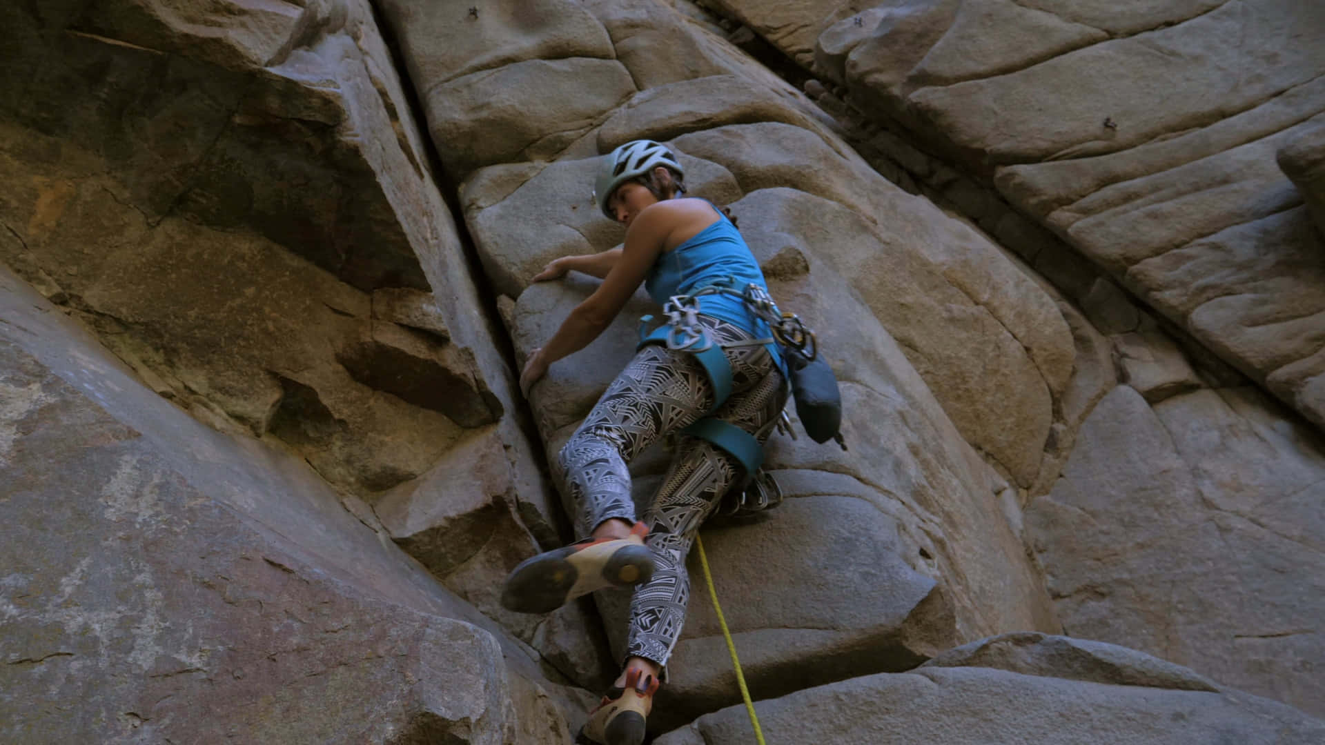 A Woman Is Climbing Up A Rock Wall