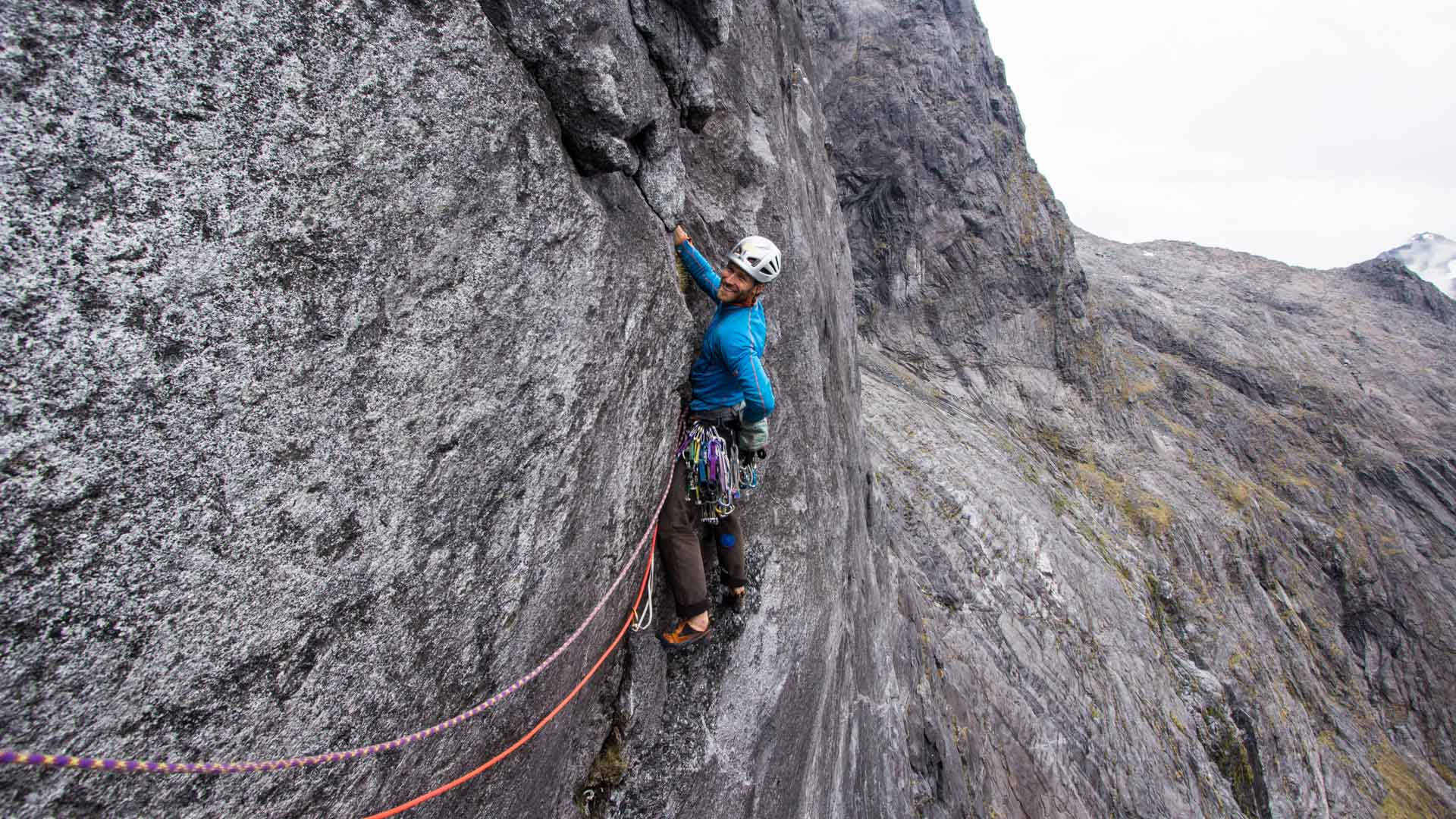 Climbing Mountaineer In Blue Wallpaper