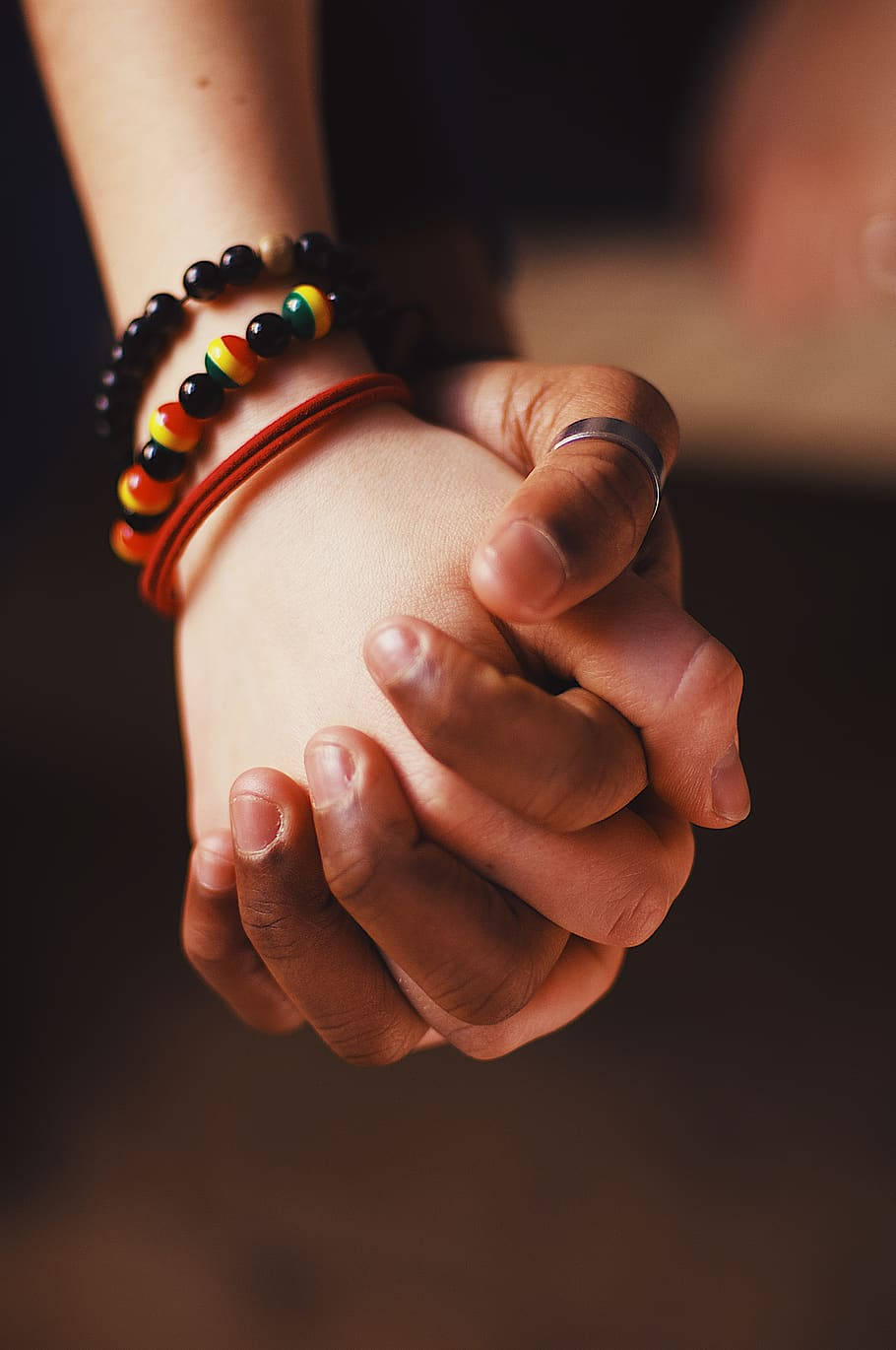 Close Up Holding Hands With Bracelets Wallpaper