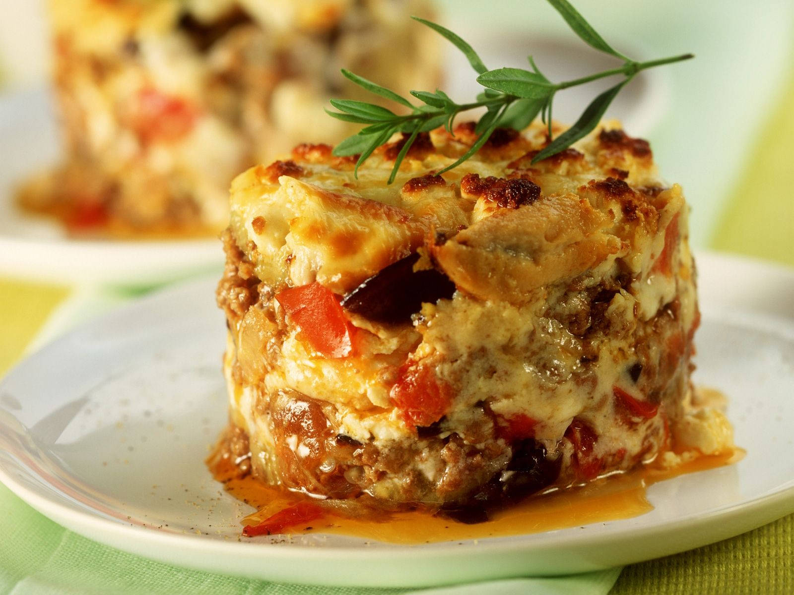Exquisite Close-Up of Savory Moussaka Garnished With Fresh Rosemary Wallpaper