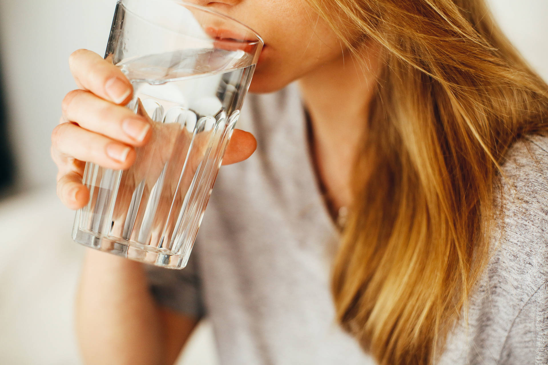 Primerplano De Una Mujer Bebiendo Agua. Fondo de pantalla