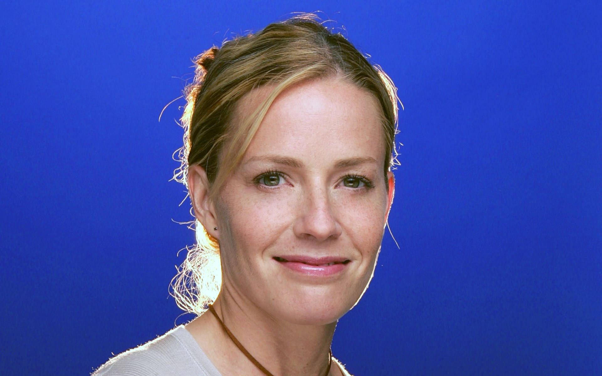 Nahaufnahmevon Elisabeth Shue Lächelnd Auf Blauem Hintergrund. Wallpaper