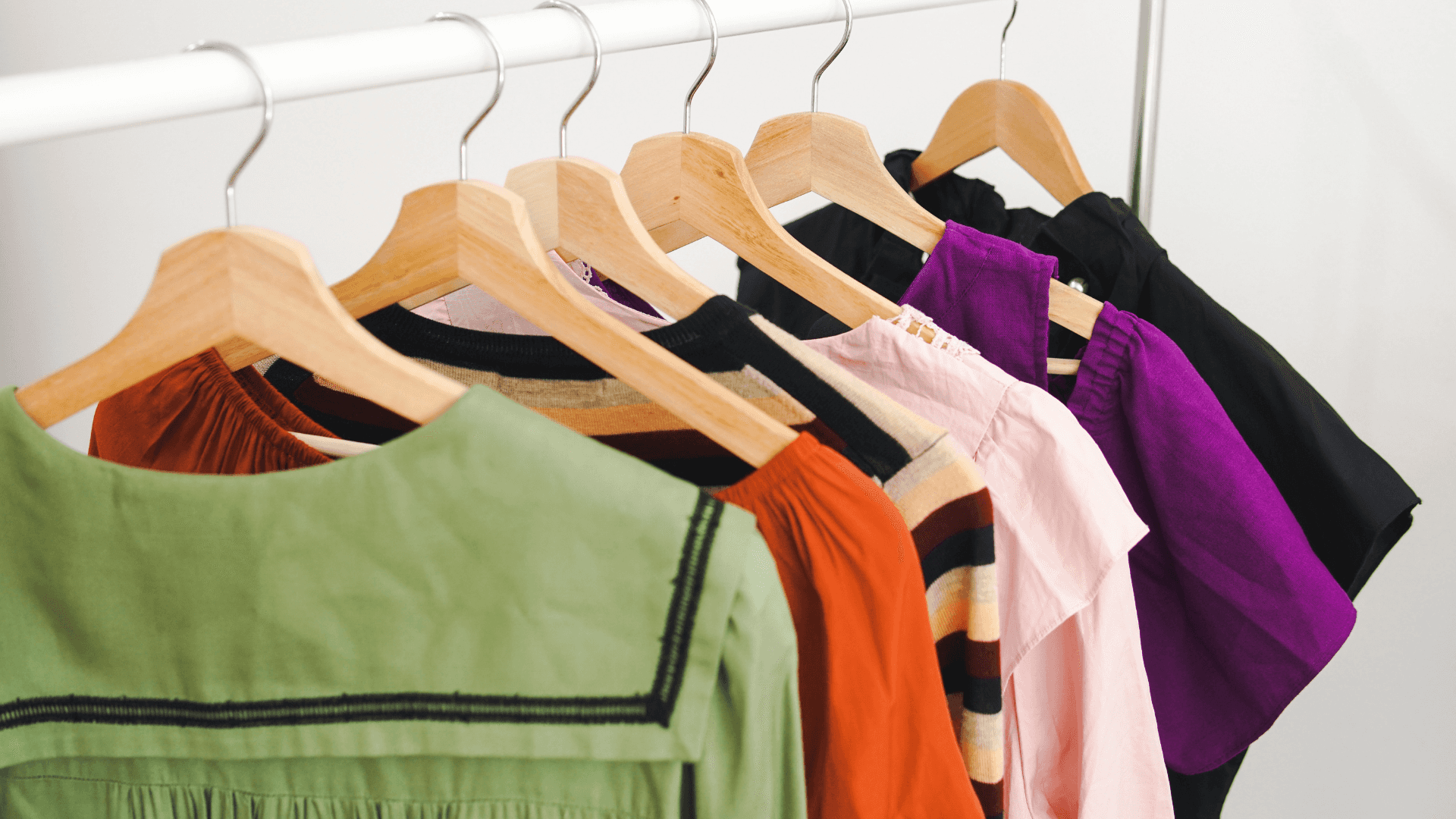 A Rack Of Clothes Hanging On A Wooden Rack