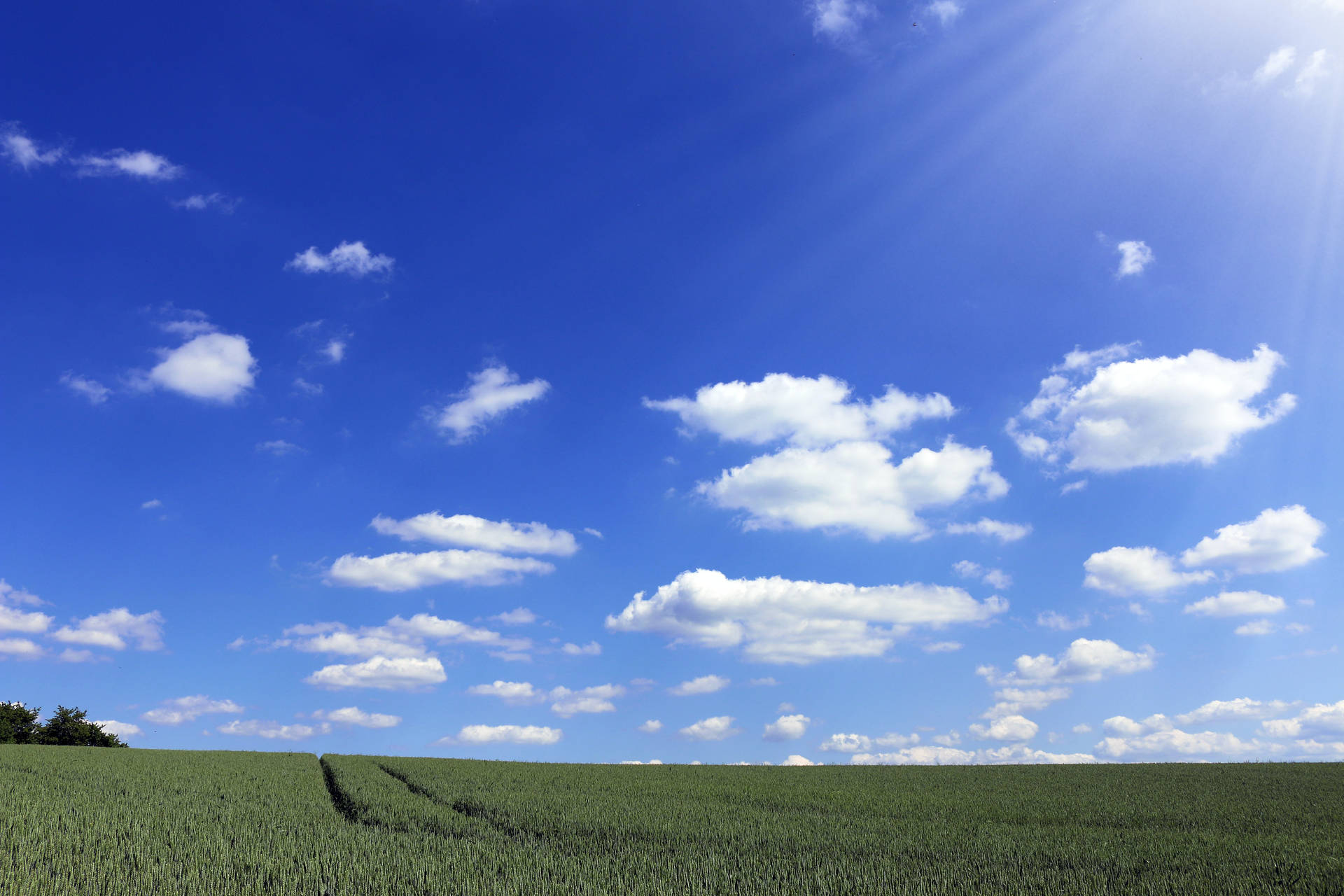 Hintergrundmit Wolken Und Grünen Feldern Wallpaper