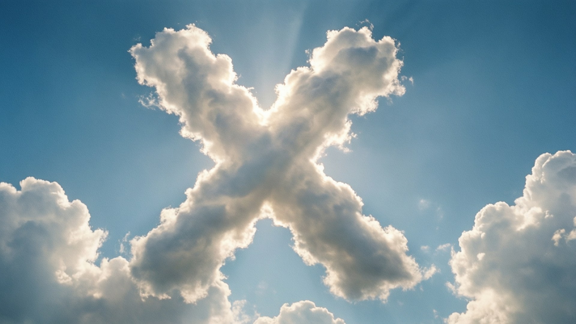 Cloud shaped like the letter X with sun rays shining through against a blue sky