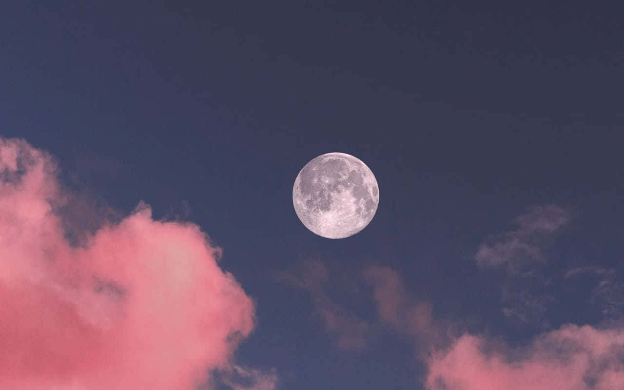 Fondode Pantalla Con Suaves Nubes Rosadas Y Una Luna.