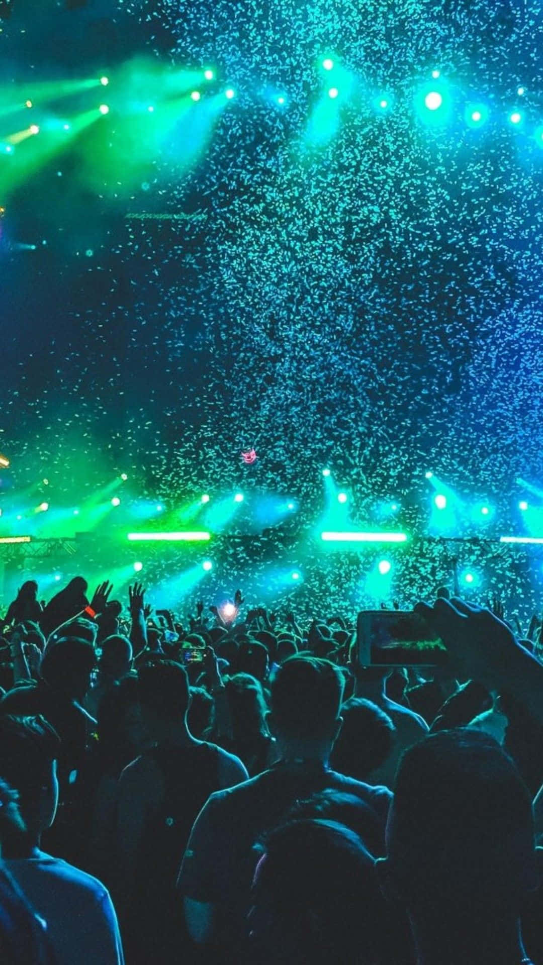 Einemenschenmenge Bei Einem Konzert Mit Grünen Und Blauen Lichtern.