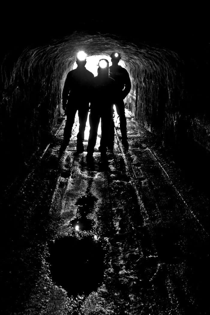 A Group Of People Standing In A Dark Tunnel