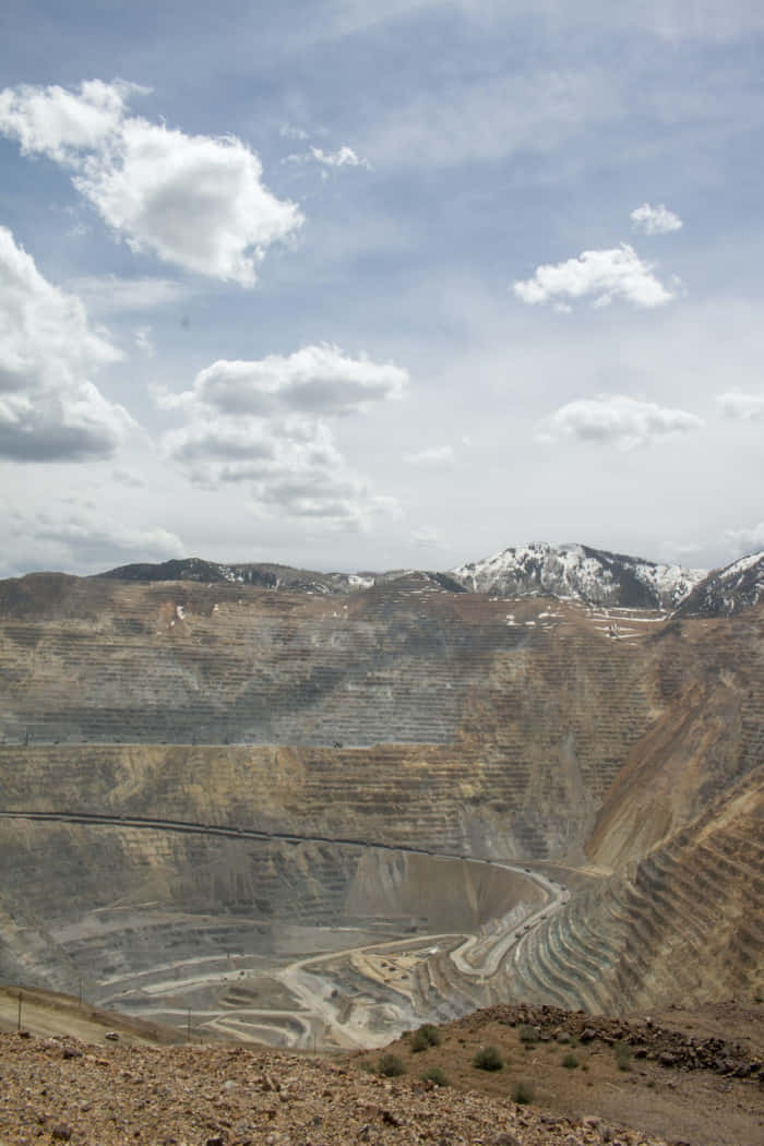 A Large Open Pit With Mountains In The Background