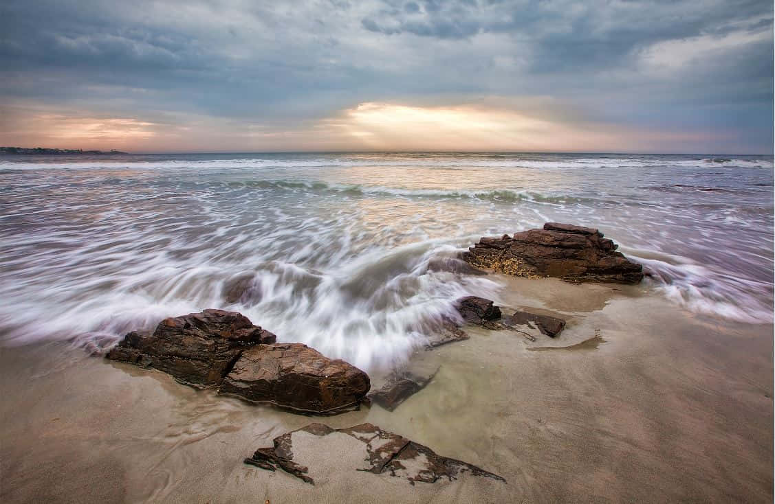 Matahari Terbenam Di Garis Pantai Yang Terjal Wallpaper