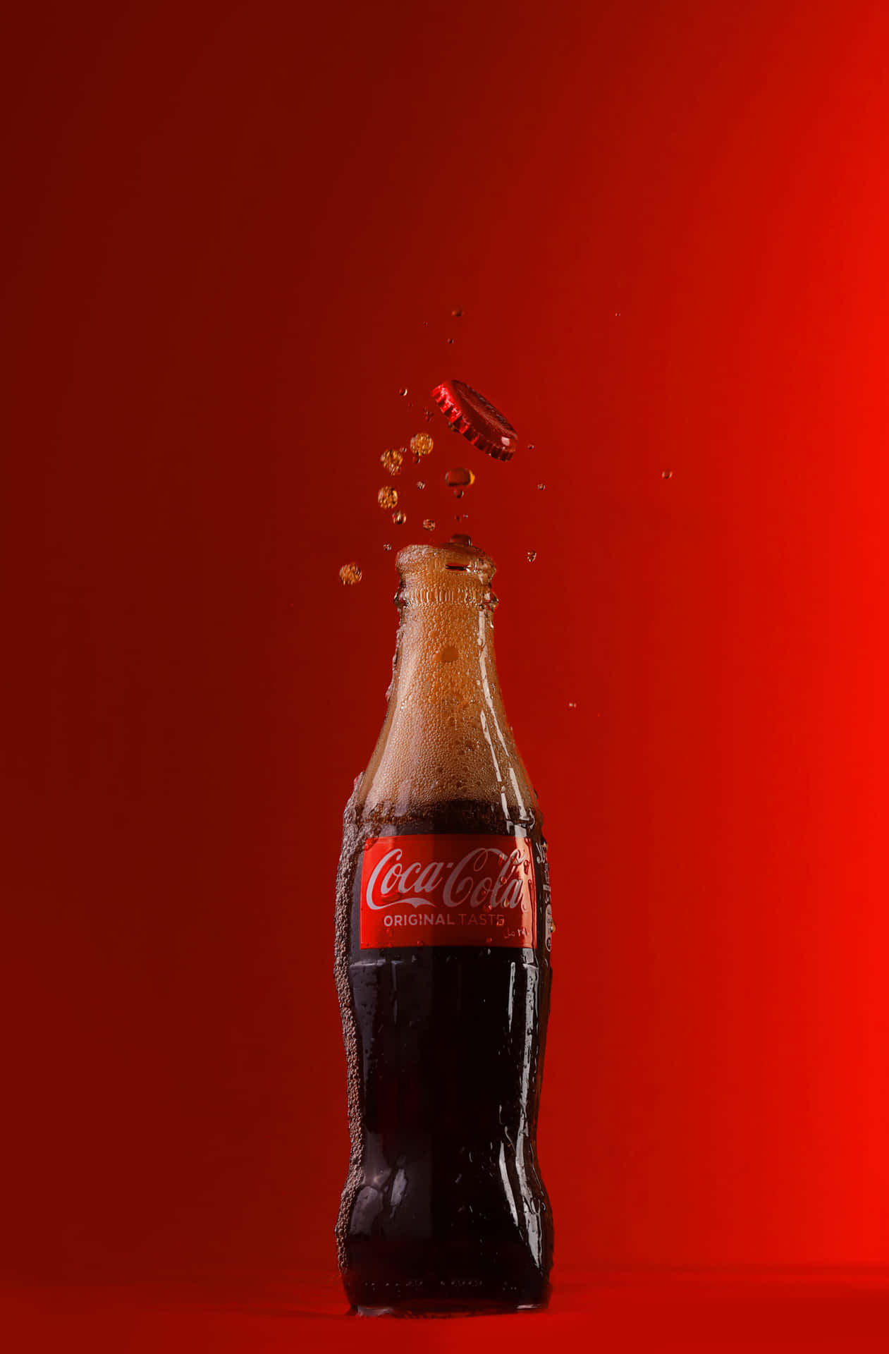 Cocacola-flaska Som Faller På Röd Bakgrund.
