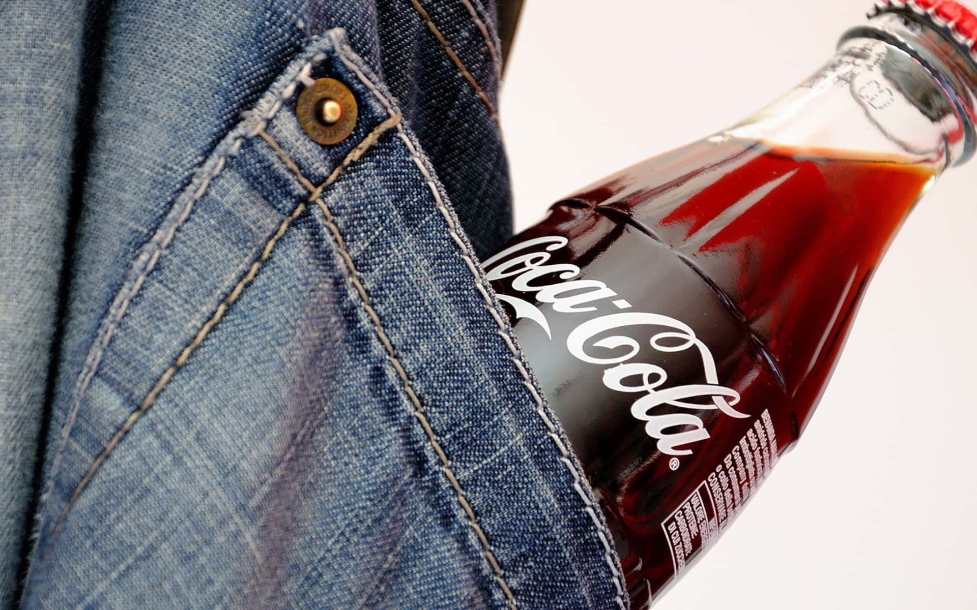 A Coca Cola Bottle In A Pocket Of Jeans