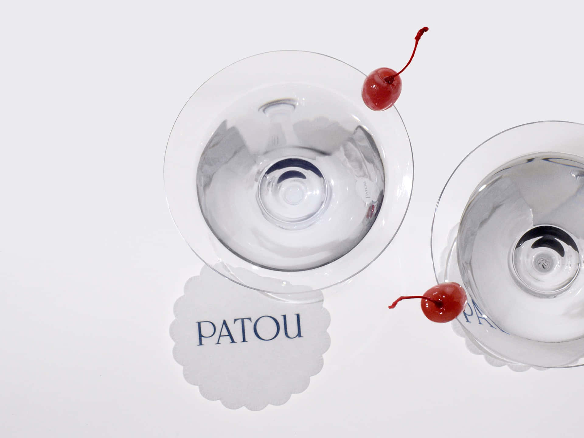 Cocktail Glasses With Patou Logo On Doily Wallpaper