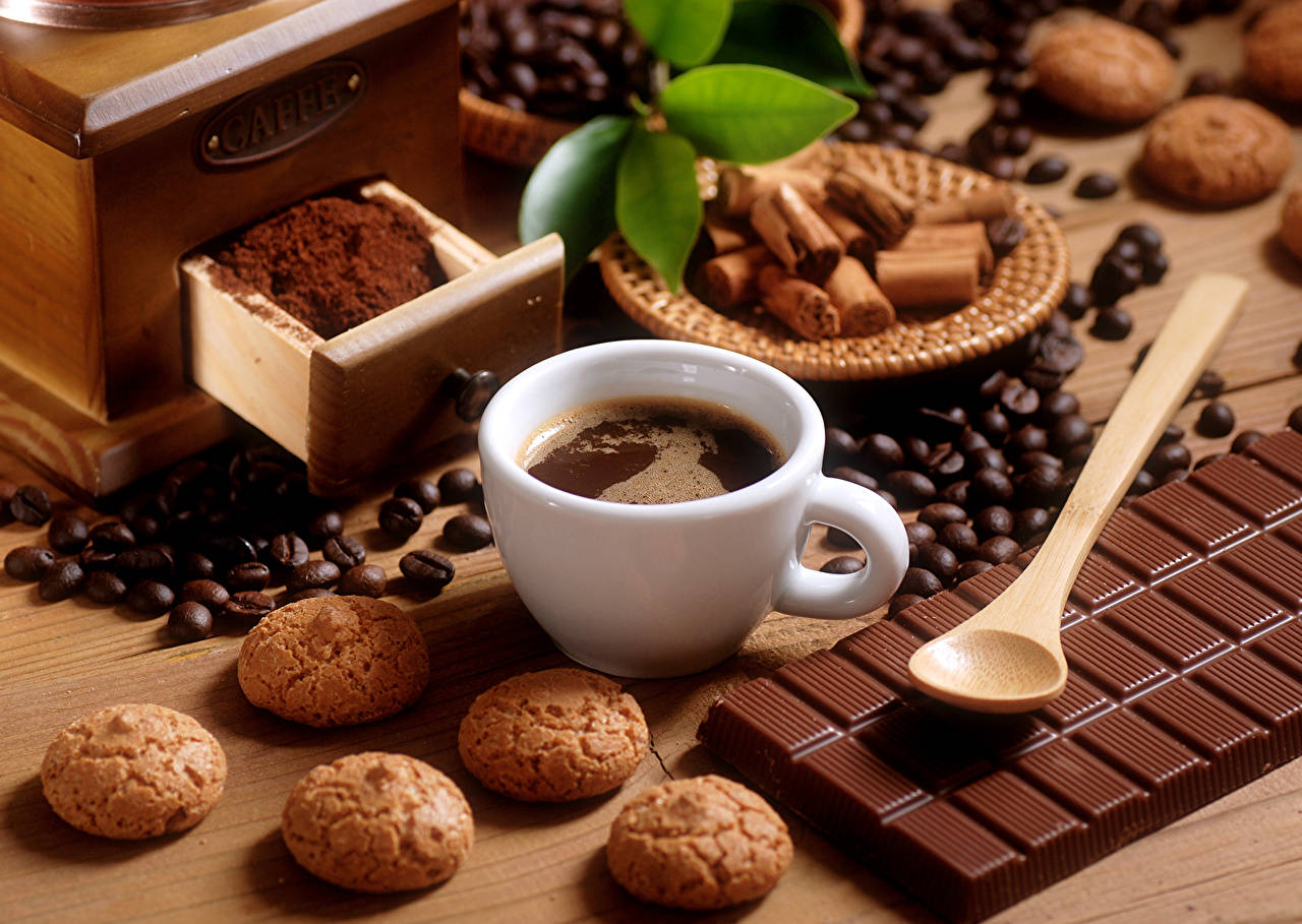 Coffee Cup Amidst Sweets And Beans Wallpaper