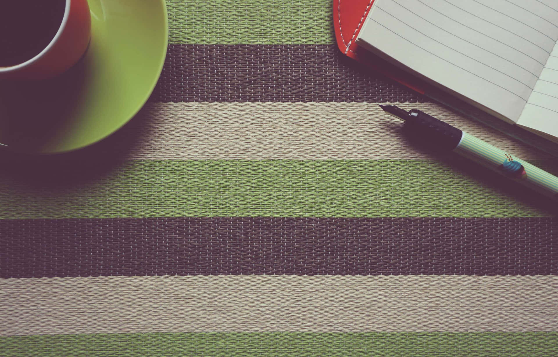 Coffee Cupand Notebookon Striped Tablecloth